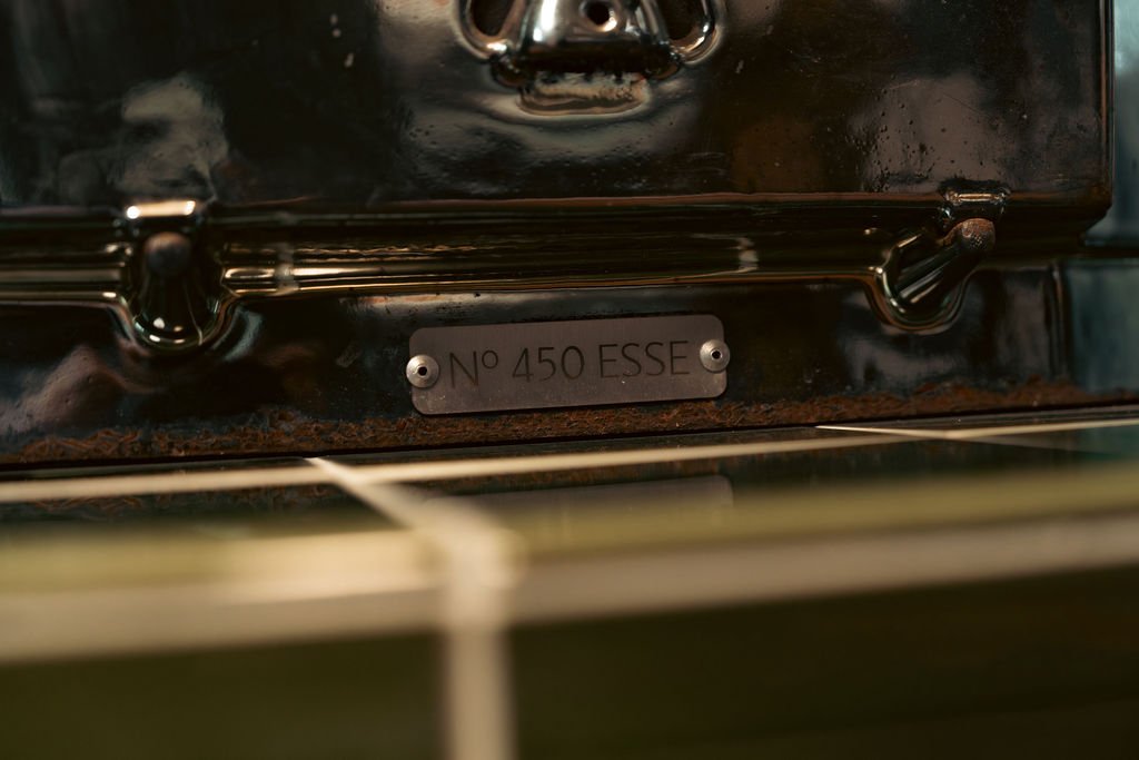 Close-up of a metallic appliance with a label reading 'No 450 ESSE' attached with two screws.