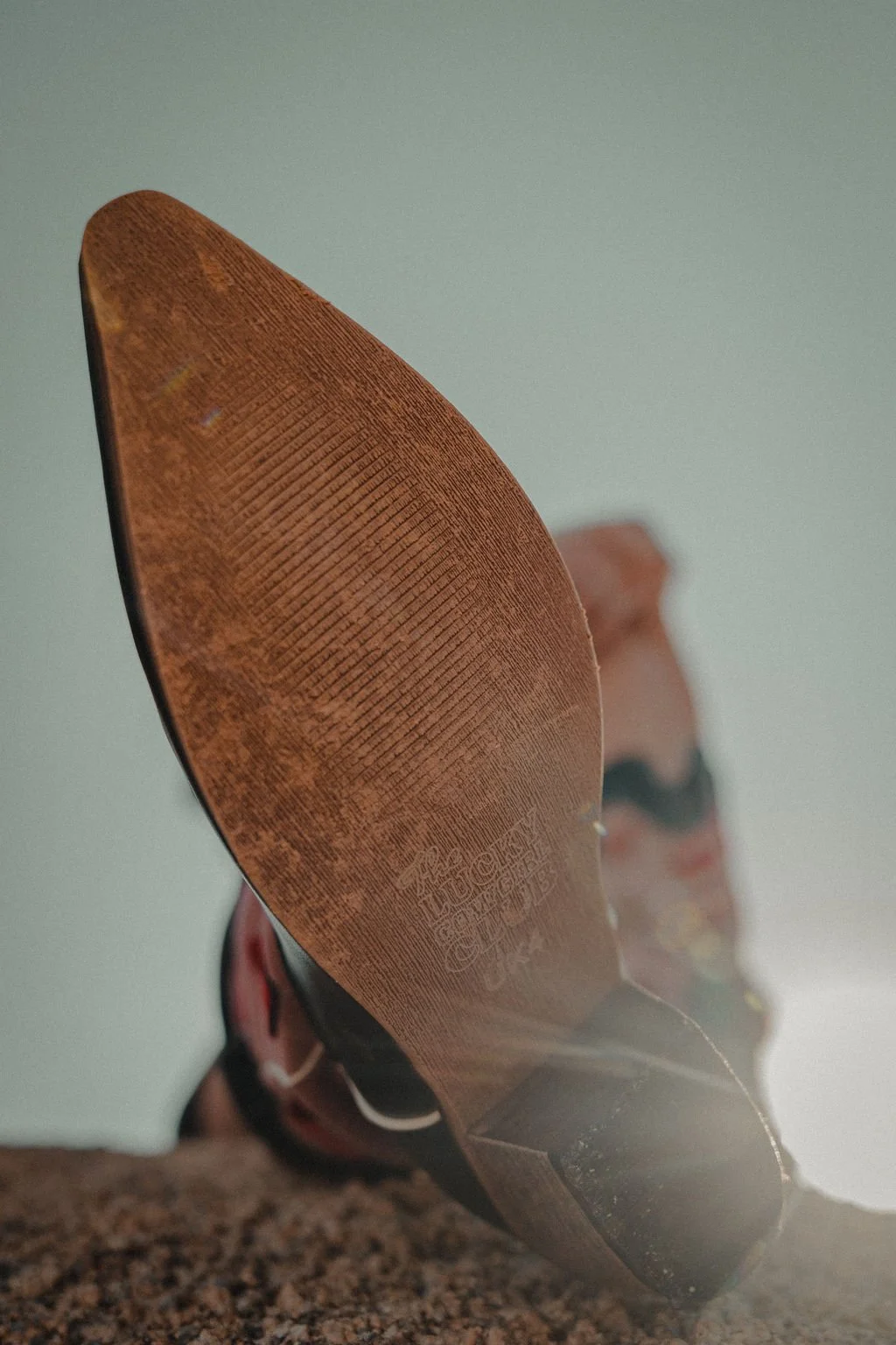 Close-up view of the sole of a tennis shoe resting on a granite surface with a blurred background.