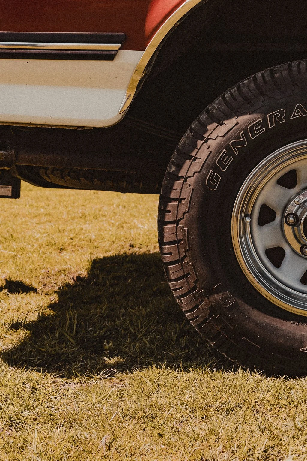 Close-up of a vehicle's front tire with the word 'GRA' visible on the tire, parked on grass.