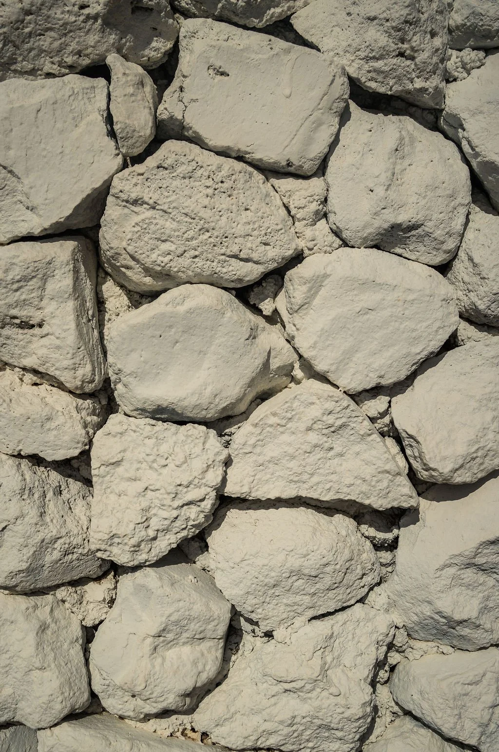 A close-up view of a wall made of irregular white stones stacked together.