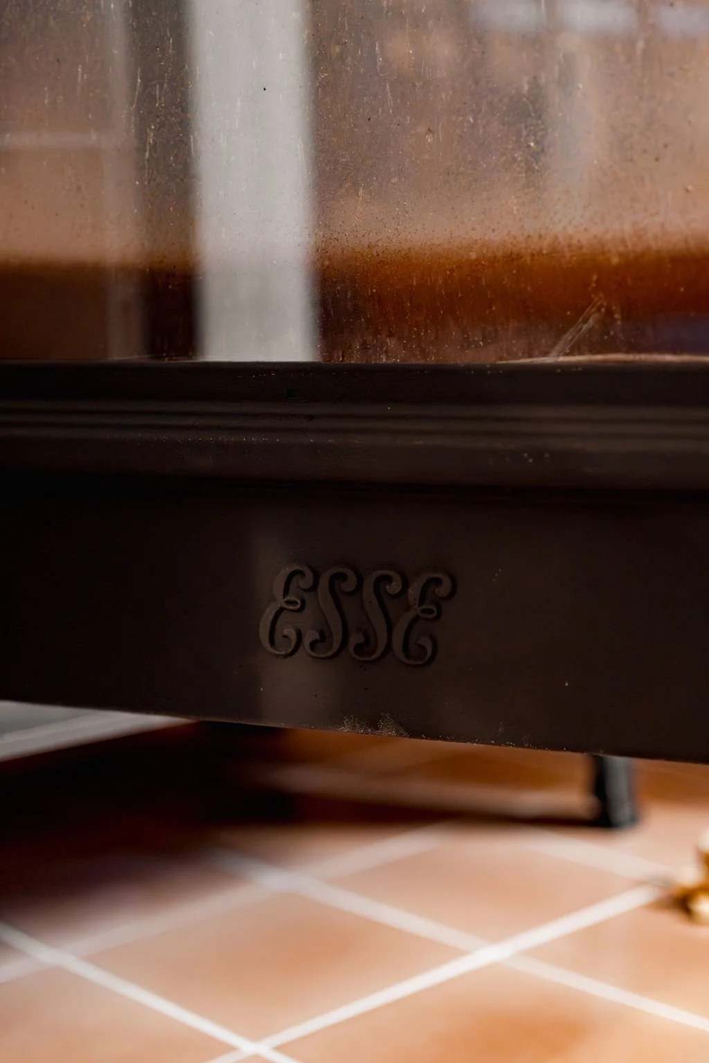 Close-up of an Esse stove machine with a logo, on a tiled floor.