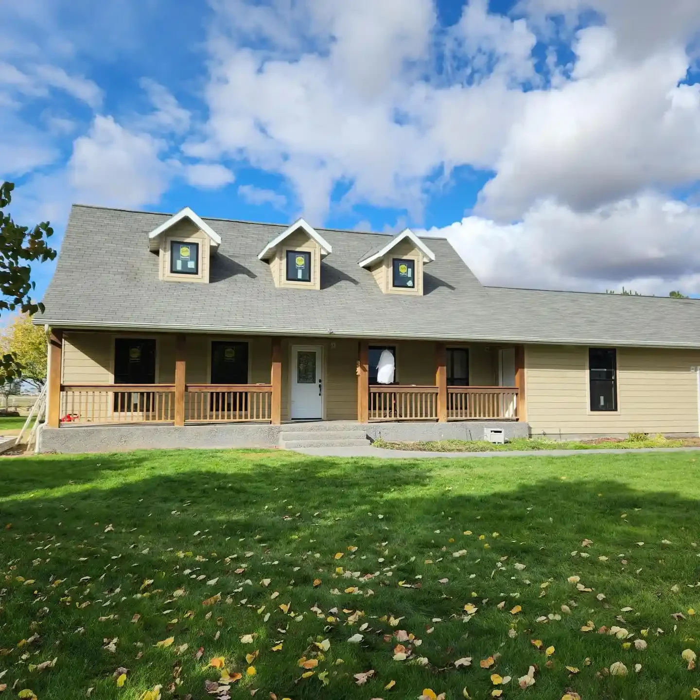 New home exterior with covered front porch and dormer windows by Jepsen Construction