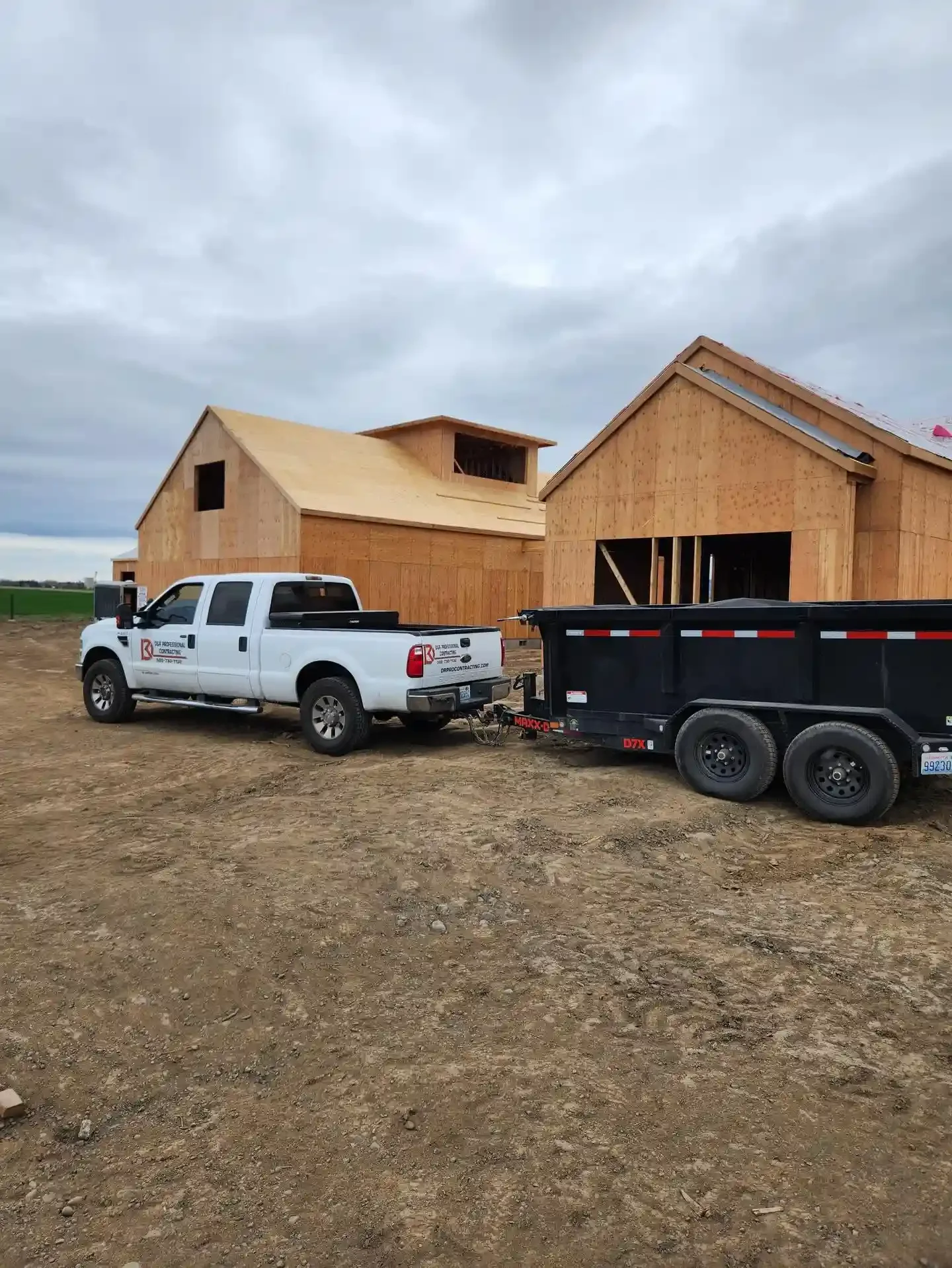 Two large buildings framed by Jepsen Construction at a rural construction site