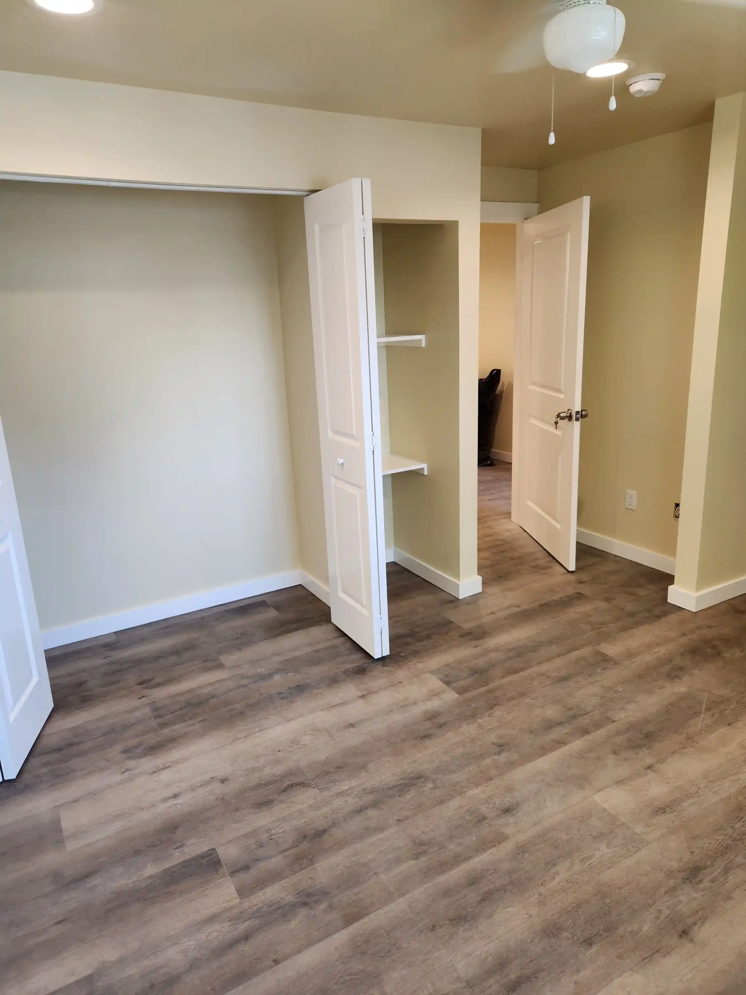 Finished bedroom renovation by Jepsen Construction with new flooring and built-in storage