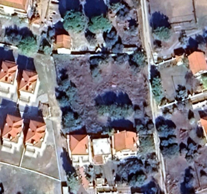 aerial view of development plot in Kallikrateia Greece showing surrounding residential area and road access. Aerial view of the project plot in Kallikrateia within an established residential neighborhood