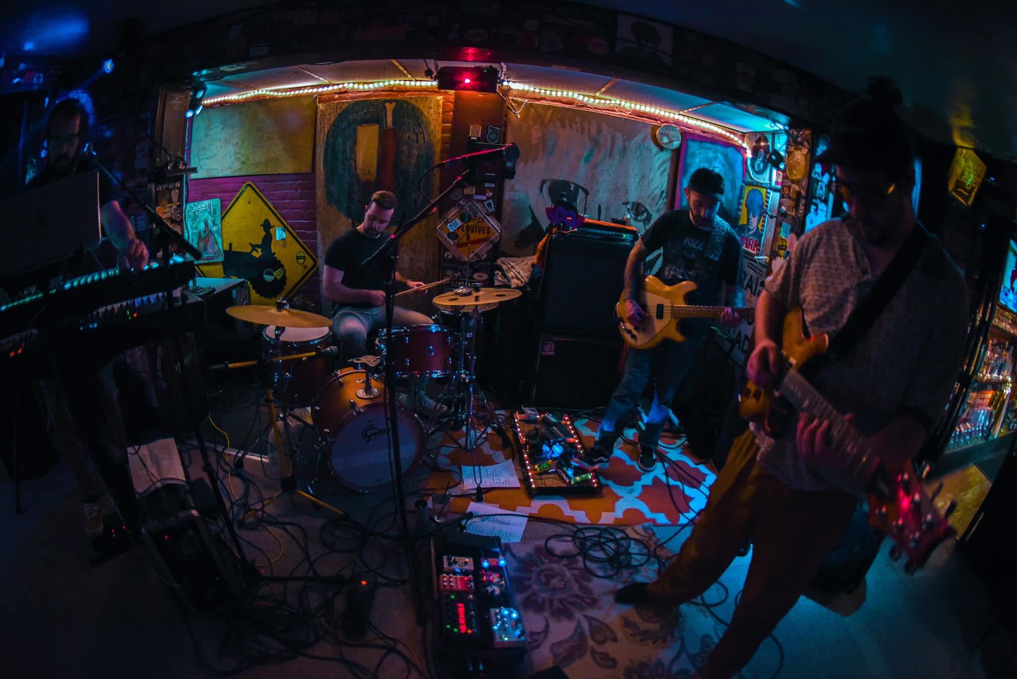 A fisheye lens view of a group of men playing music on instruments