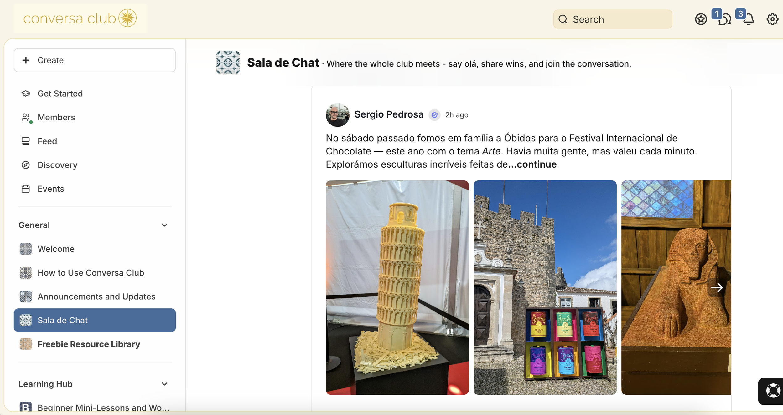 Three images displayed side by side showing various artworks: the first is a detailed sculpture resembling the Leaning Tower of Pisa made of yellow material, the second is a colorful display of books or artworks outside an old stone building with a cross, and the third is a carved stone statue of a seated figure with a stylized face, inside a room with wooden walls and a window.