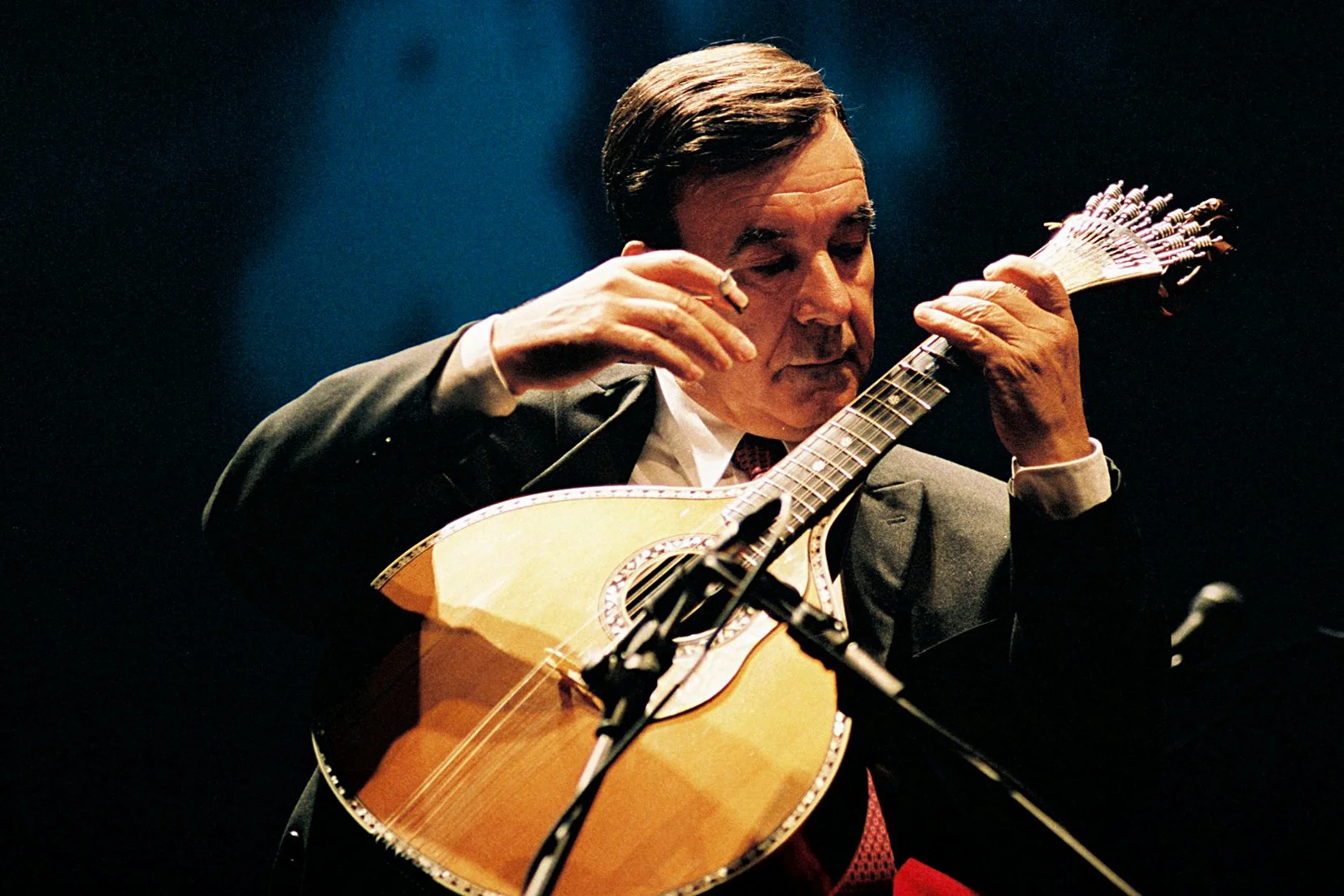 Photo of Portuguese musician, António Chainho, on stage performing with his instrument, the guitarra portuguesa
