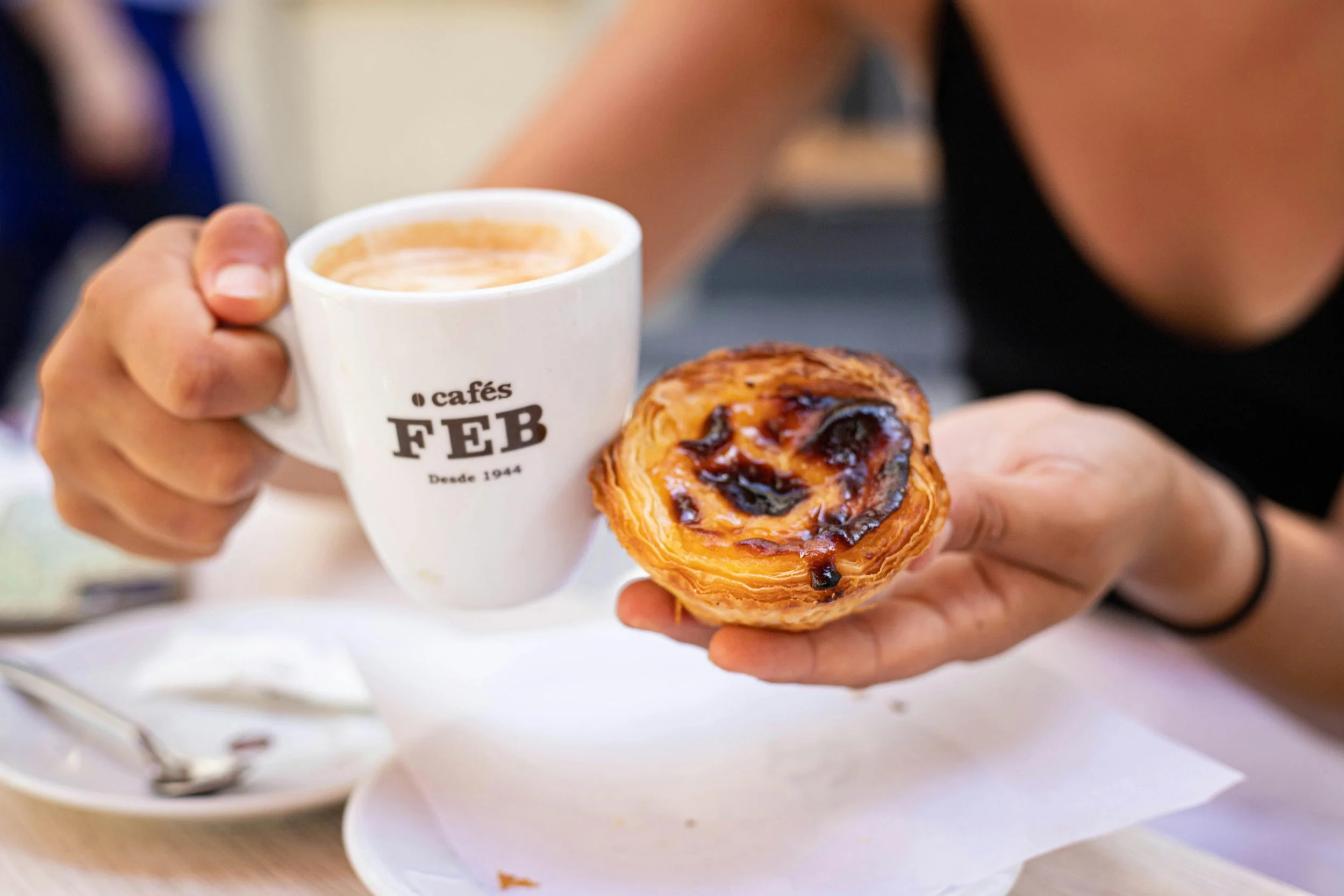 Picture of a coffee mug and pastel de nata pastry at FEB cafés - a traditional Portuguese coffee roasting and manufacturing company based in Coimbra Portugal. Photo take by Michael Santos.
