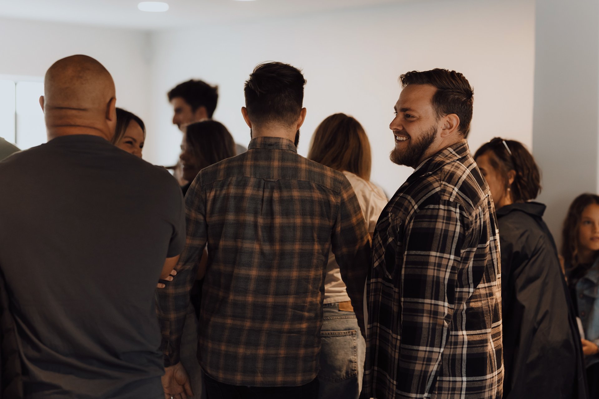 Group of people socializing indoors, smiling and talking