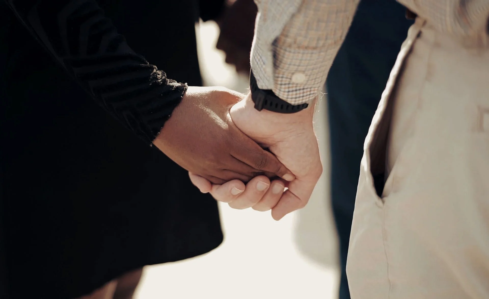 Black woman holding hands with white man