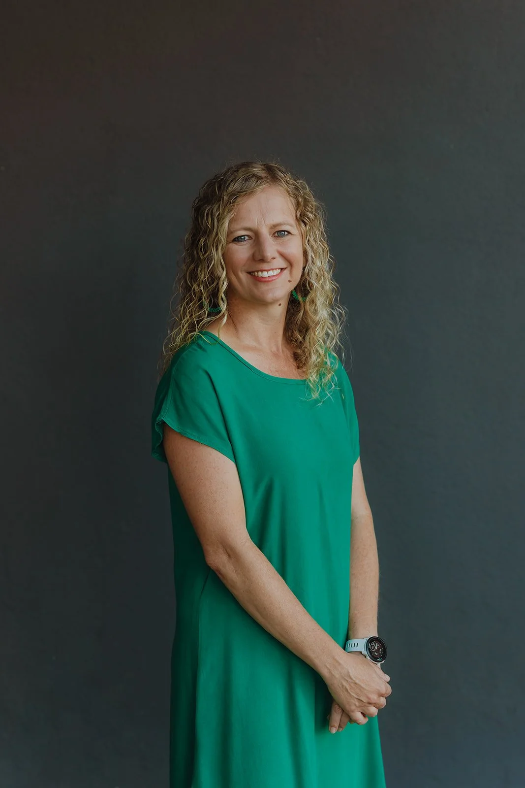 Group of seven diverse people standing outdoors on a sunny day, smiling and posing for a photo in a residential neighborhood.
