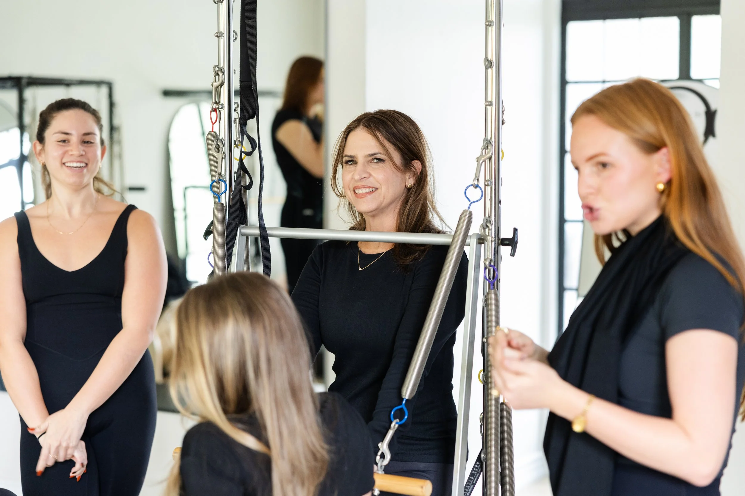 three woman in a Pilates studio smiling