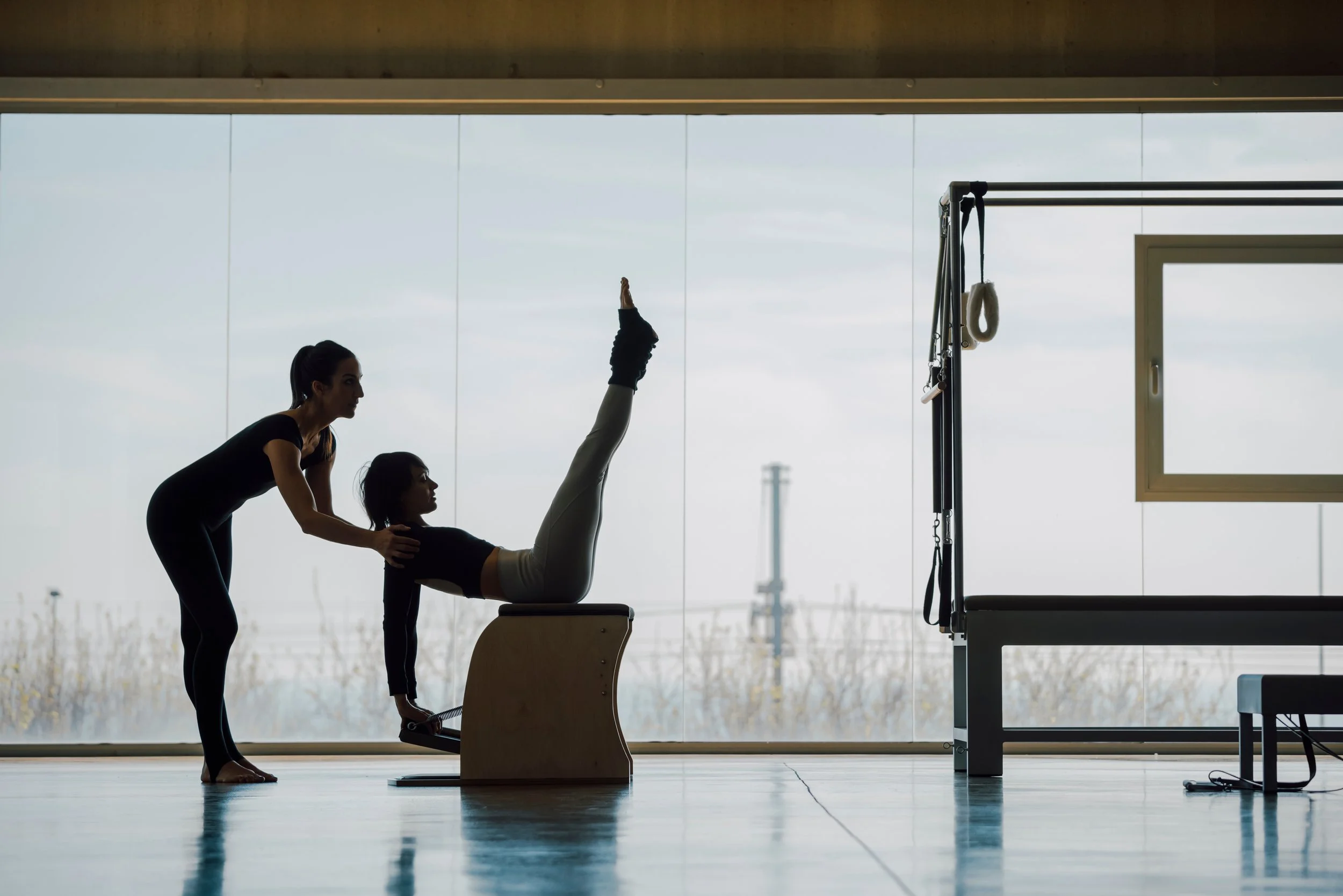 Pilates teacher leading a client on the Wunda chair.