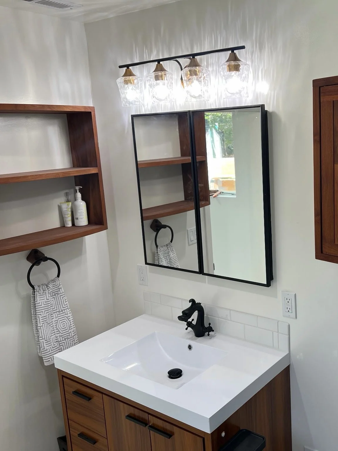 A finished look at this Art Deco bathroom / dressing room remodel. We love the way the teak vanity and sink combo brings out the colors in the terrazzo tile floor. The shower features a Schluter system, built to last behind the tile.