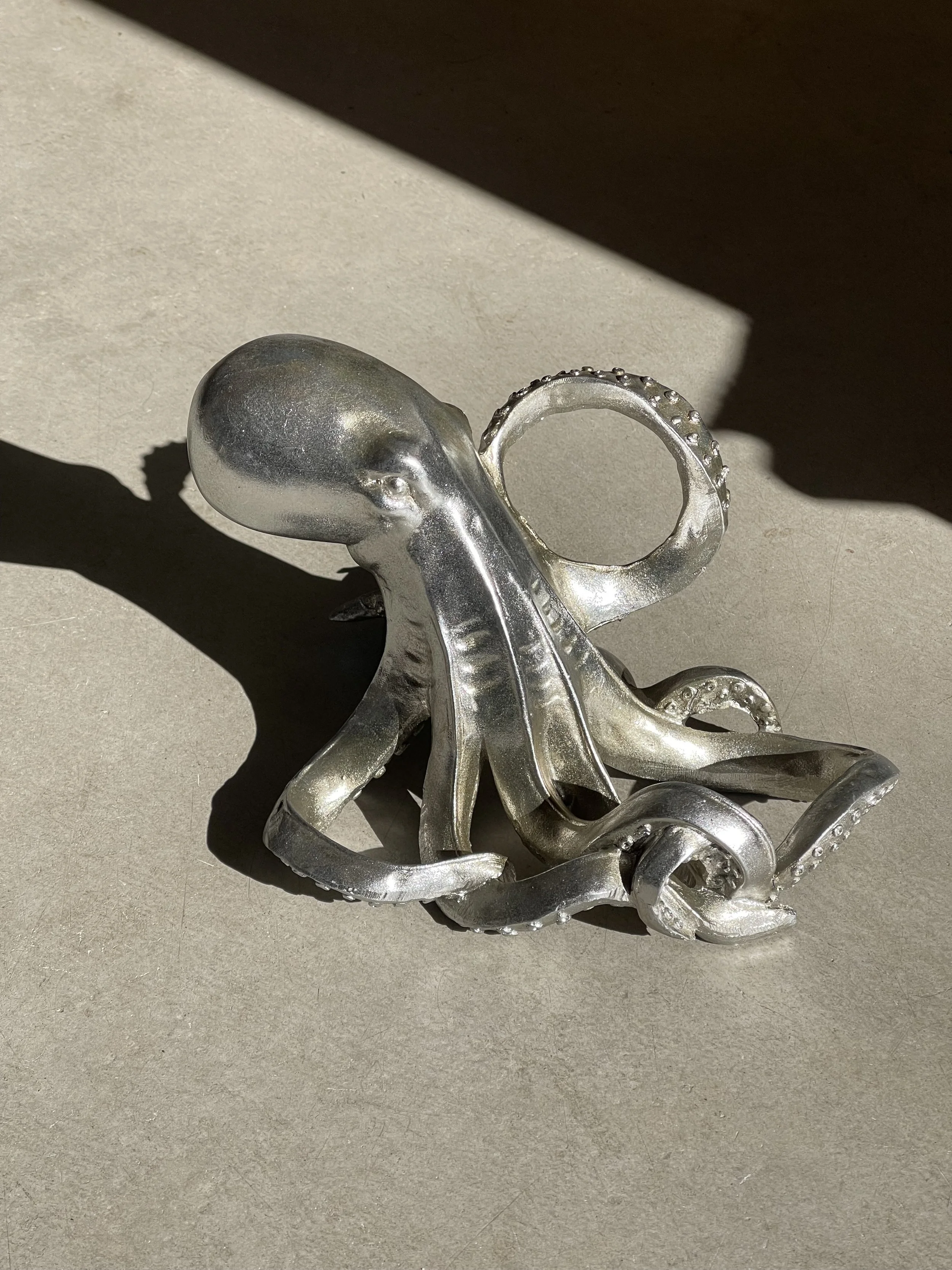 Silver octopus wine bottle holder perfect for coastal decor and quirky homeware. Avilable in Ruby's Designs giftshop in Looe, Cornwall.