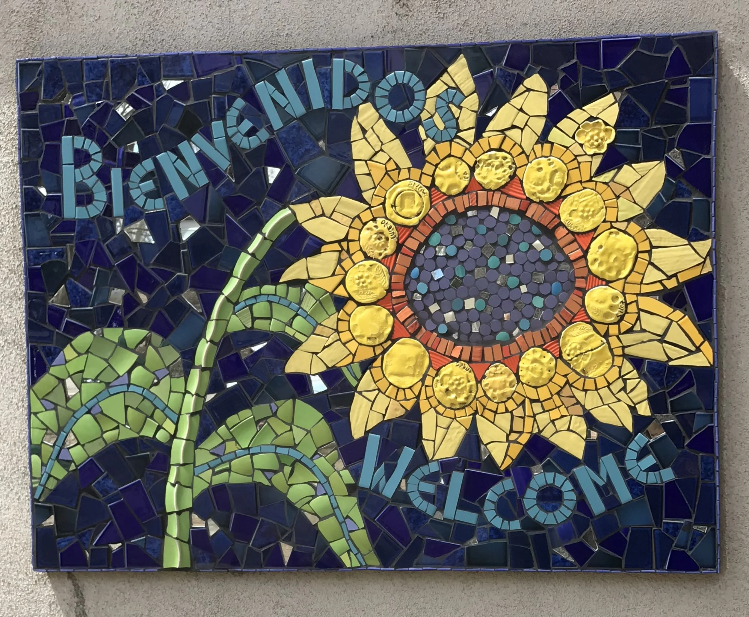 Ceramic and tile entrance sign with children’s  handmade clay flowers,  La Puerta de los Niños Preschool, Albuquerque, NM