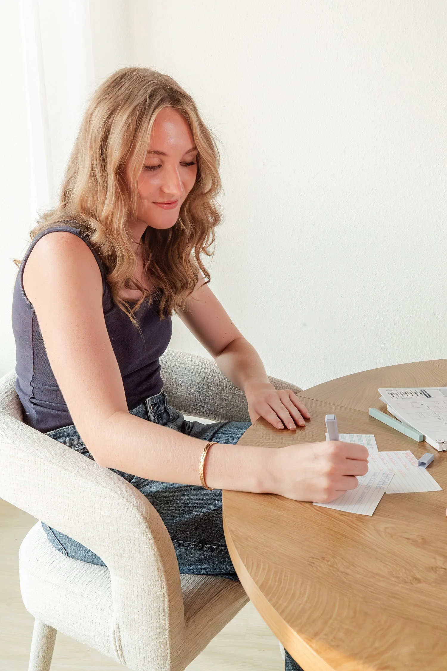 Adelyn writing on study index cards at a wooden table in Jordan Brittley Studio
