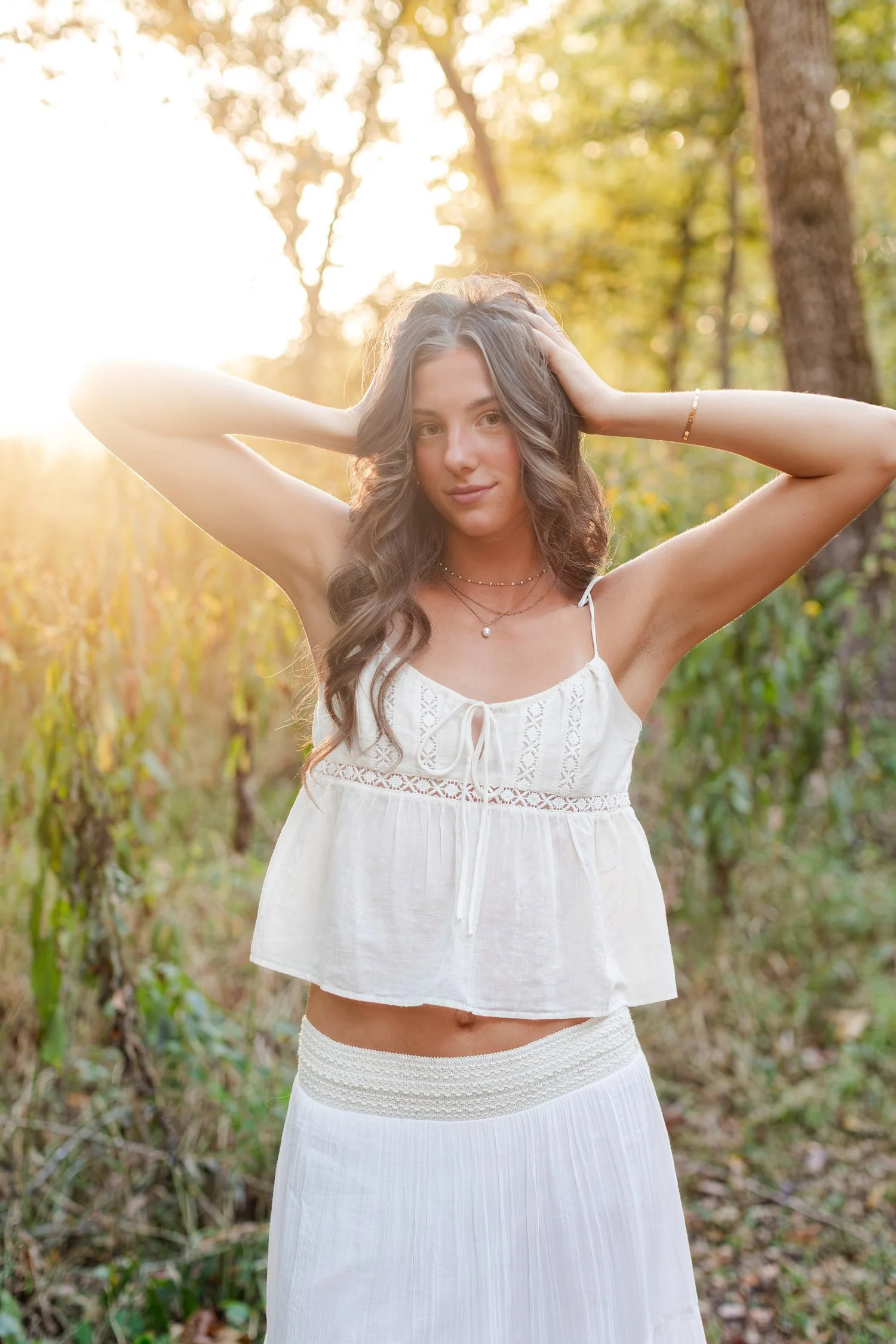 Eisley with her hands in her hair, backlit by the setting sun near Bolivar, MO