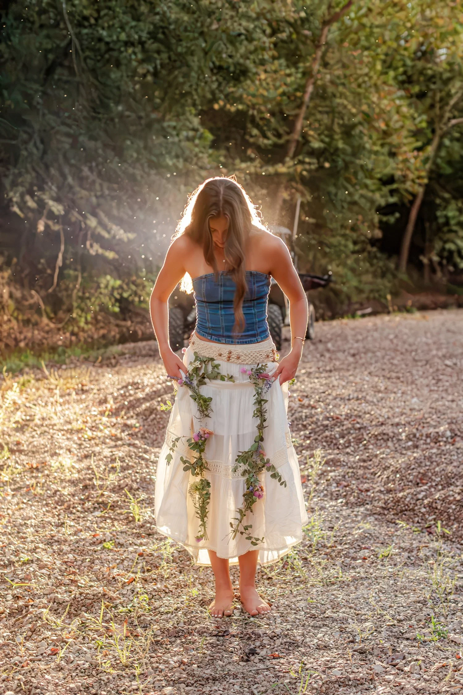 Eisley backlit with a vine garland draped over her skirt, senior pictures near Bolivar, MO