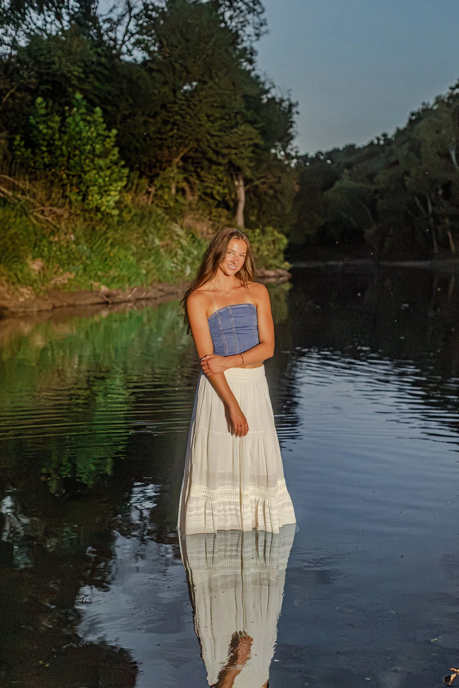 Eisley standing in the river at dusk with her reflection, senior pictures near Bolivar, MO