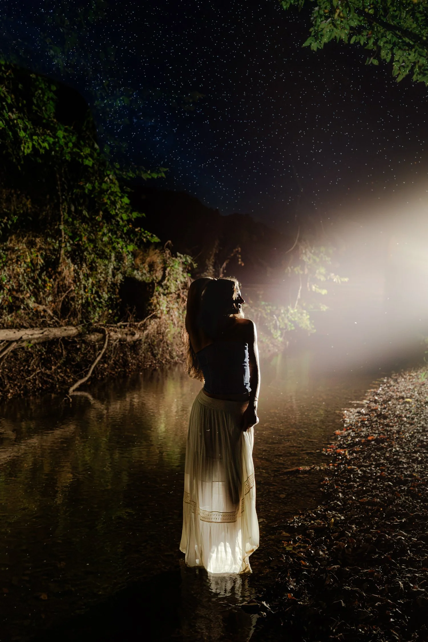 Eisley in the river at night with her back to the camera, senior pictures near Bolivar, MO