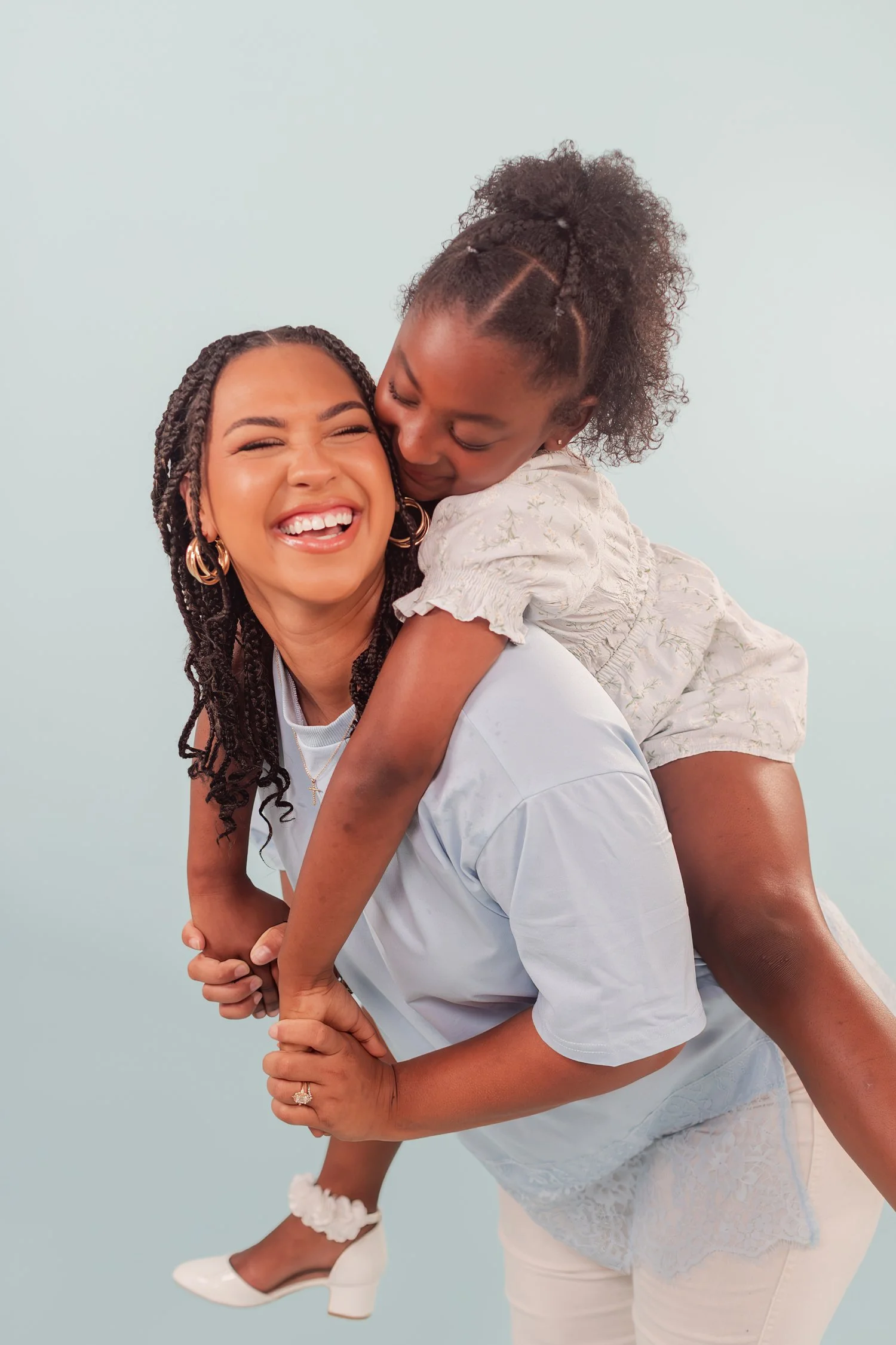 Daughter hugging mother from behind during a piggyback ride, both laughing, mother daughter photos in Bolivar, MO