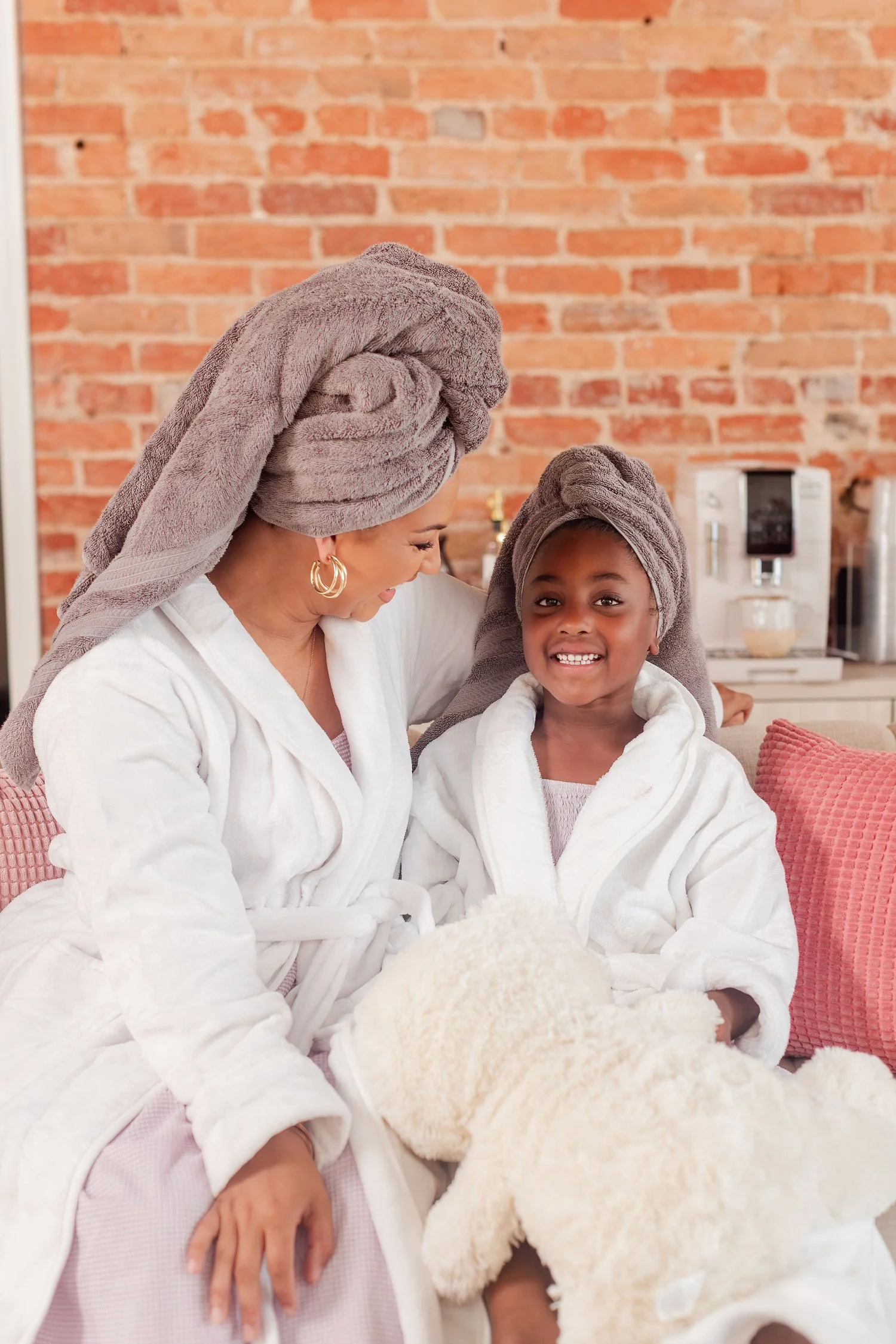 Mother and daughter in robes and towel wraps sitting together on a couch with a teddy bear, mother daughter photos in Bolivar, MO