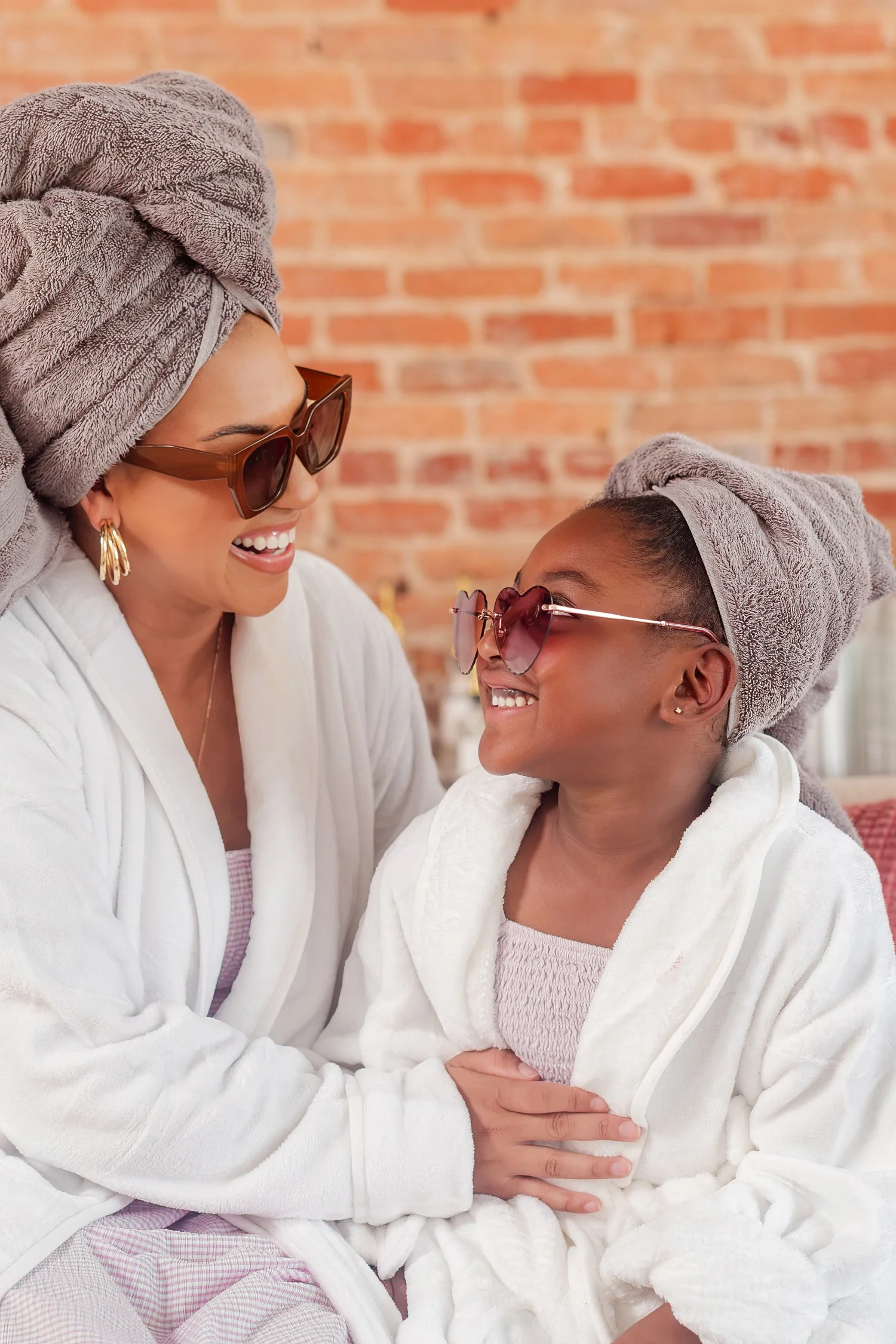 Mother and daughter in robes, towel wraps, and sunglasses smiling at each other, mother daughter photos in Bolivar, MO