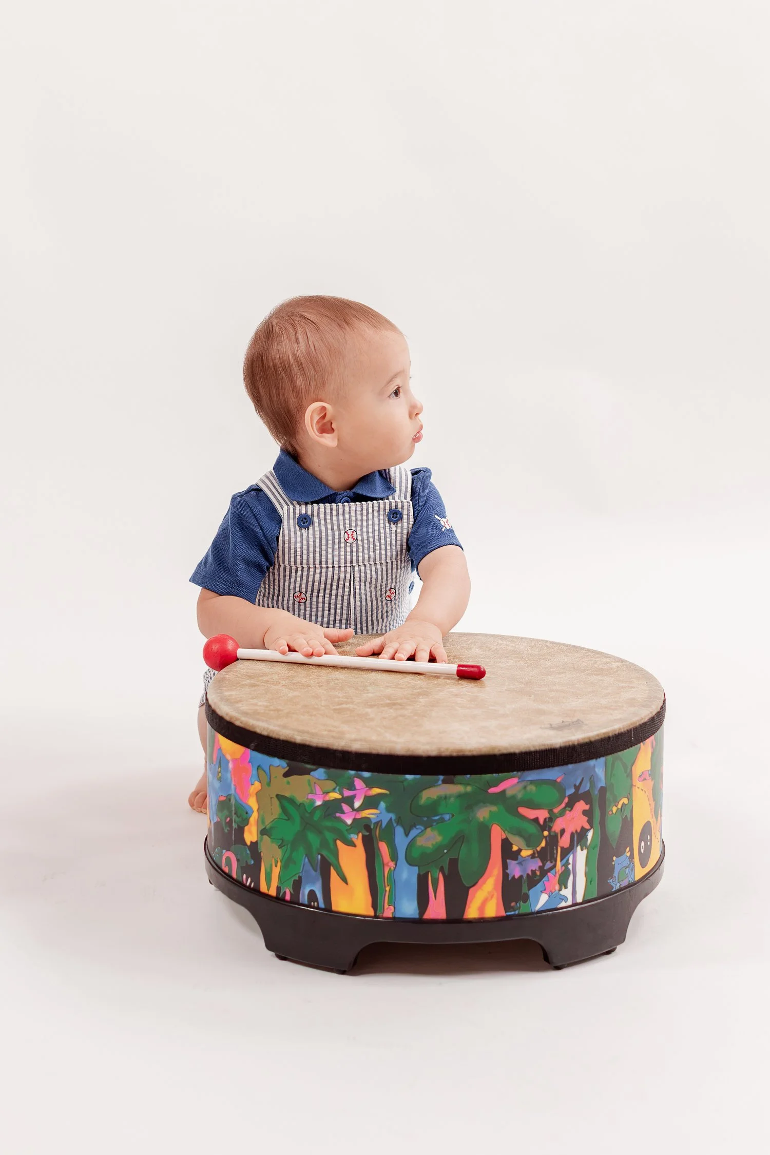 Winston standing behind his drum in blue striped overalls