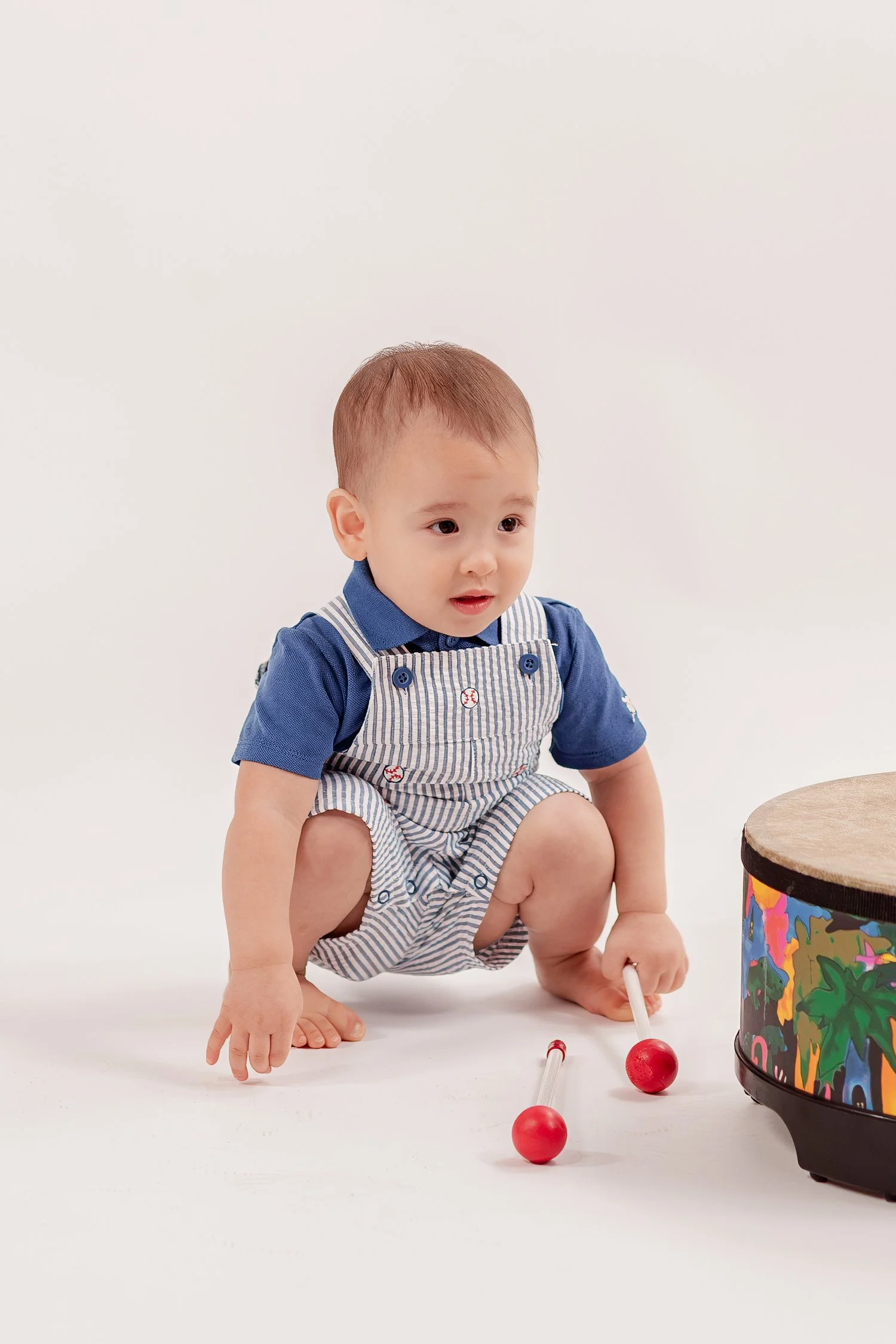 Winston sitting beside the drum and red-tipped mallets