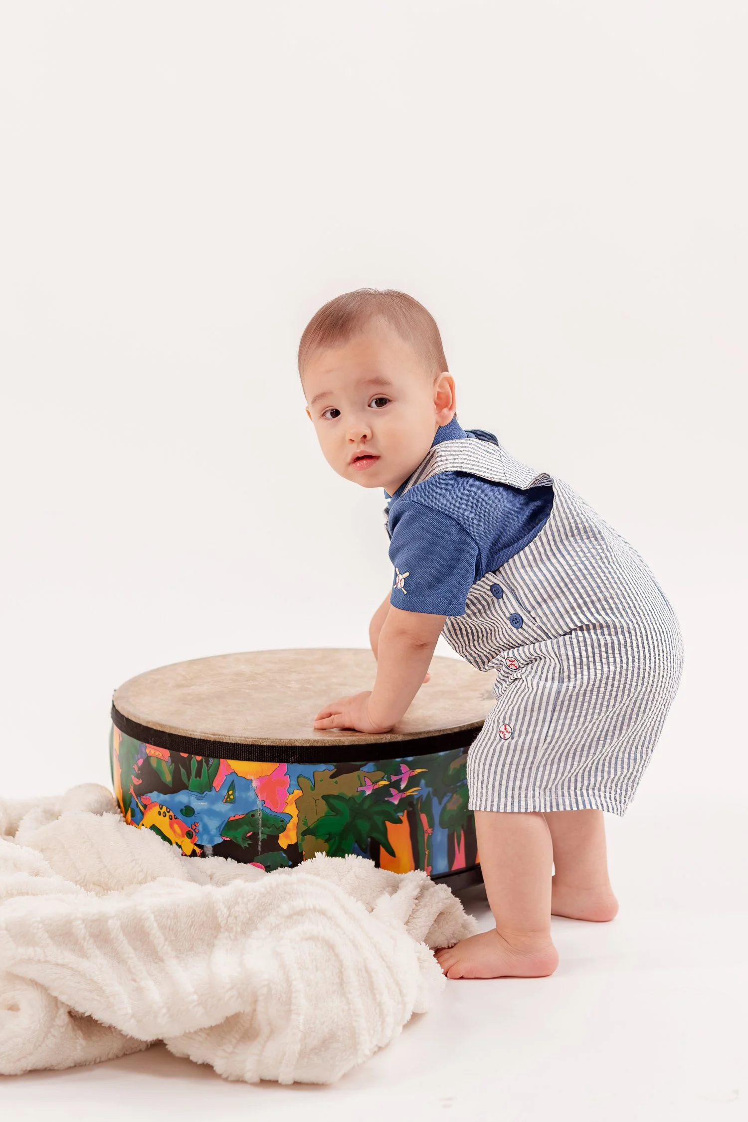 Winston leaning on his drum beside a blanket