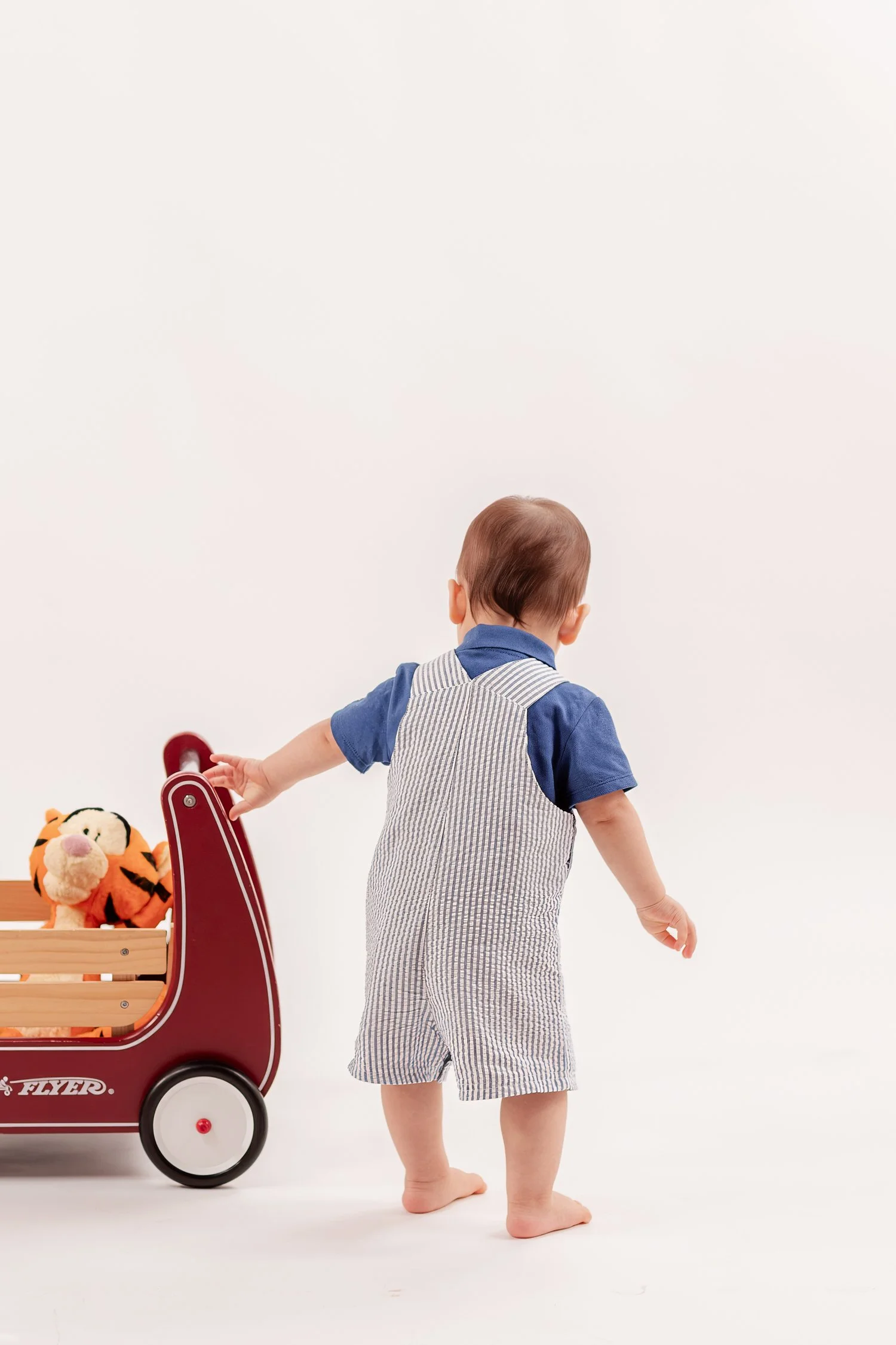 Winston standing with one hand on his red wagon