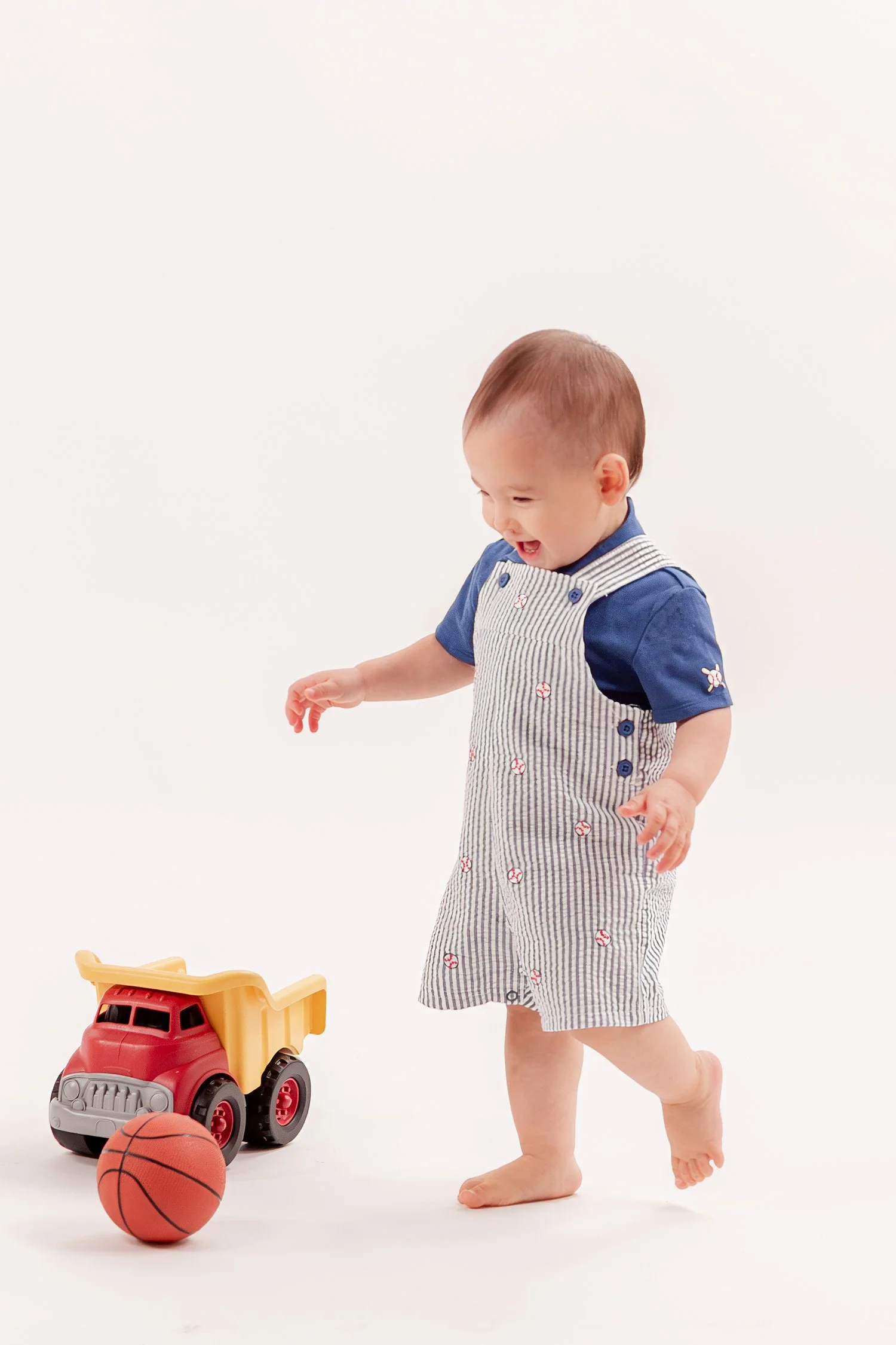 Winston standing beside a toy dump truck and basketball