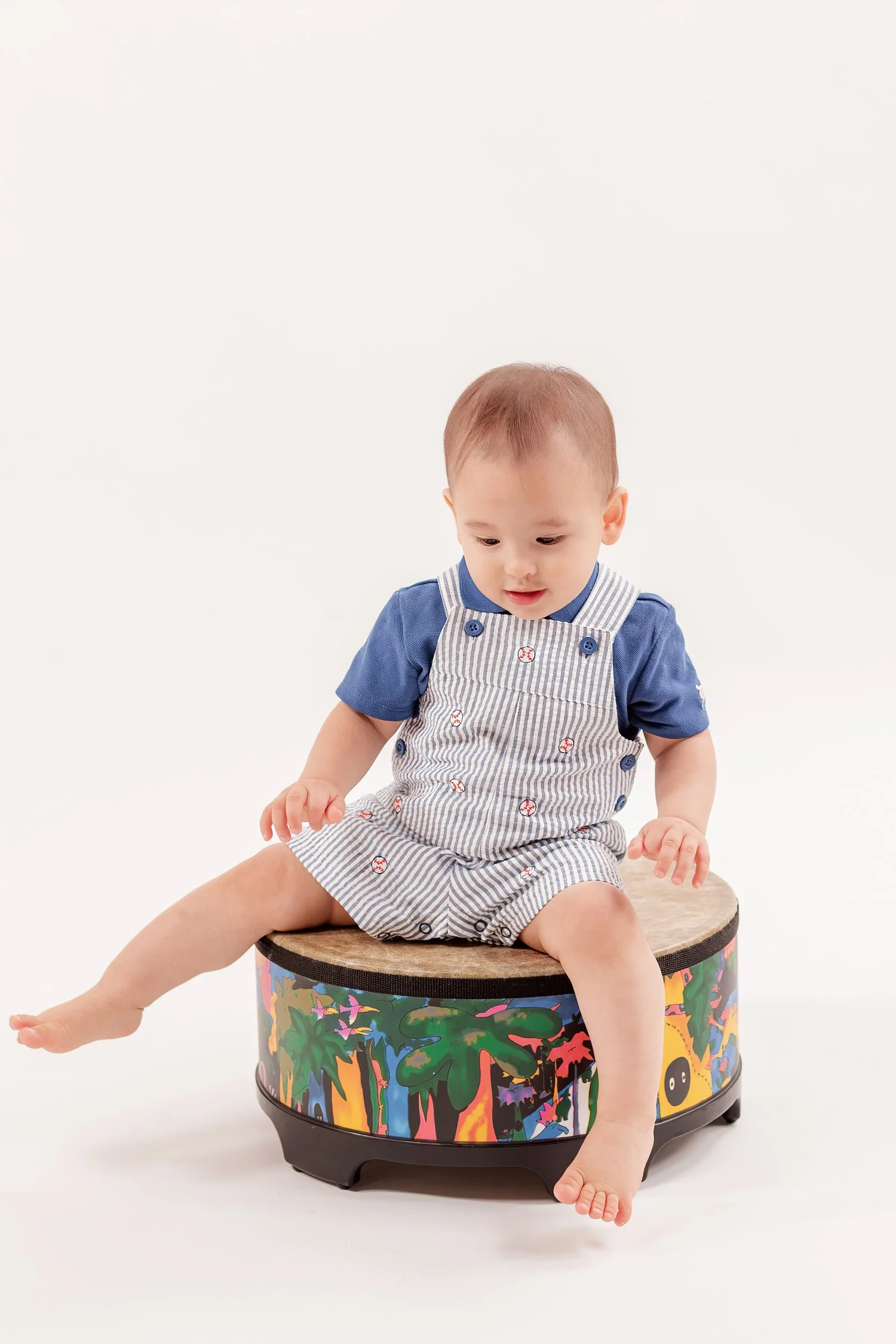 Winston sitting on his drum with one leg stretched out
