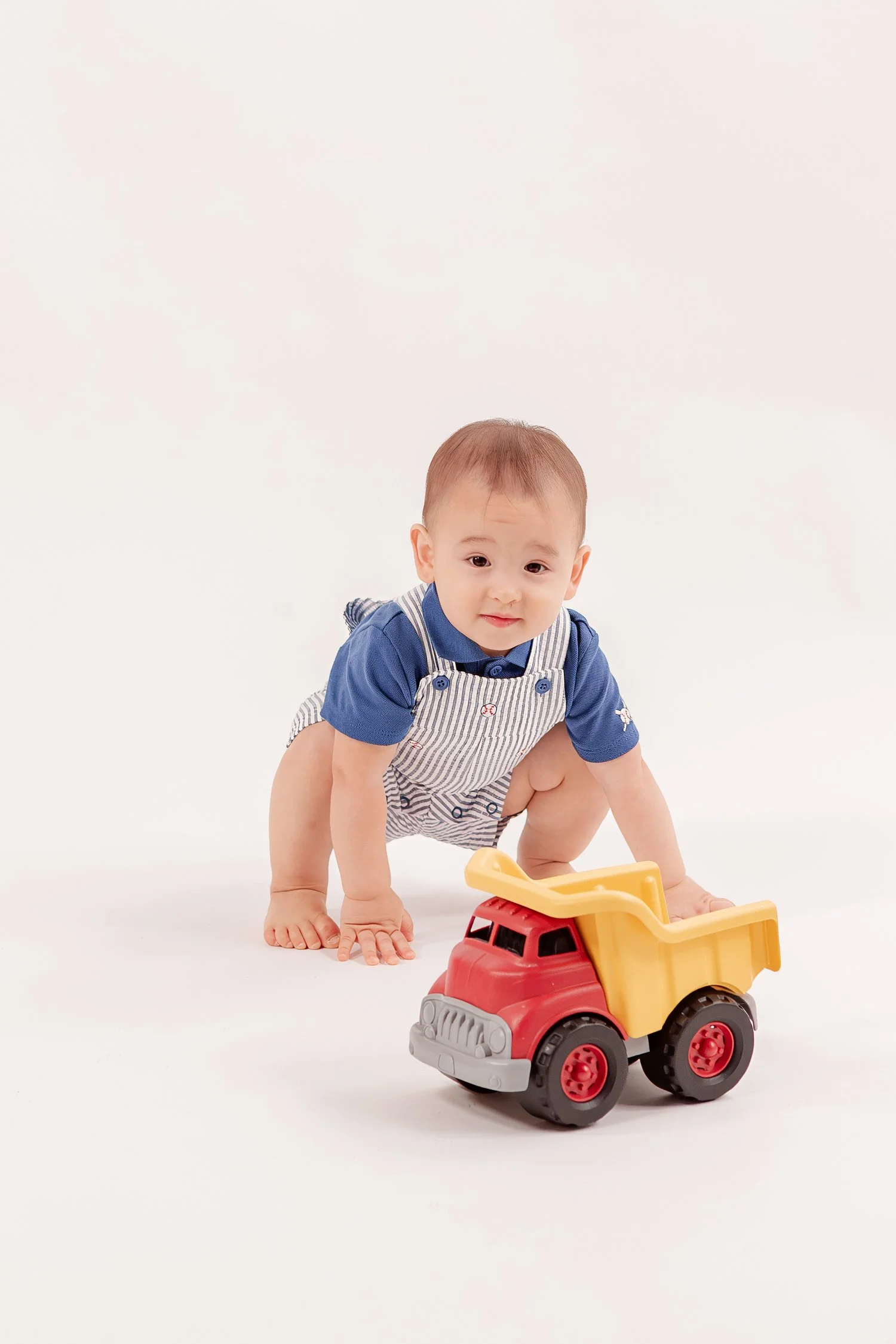 Winston crouching behind the red and yellow dump truck