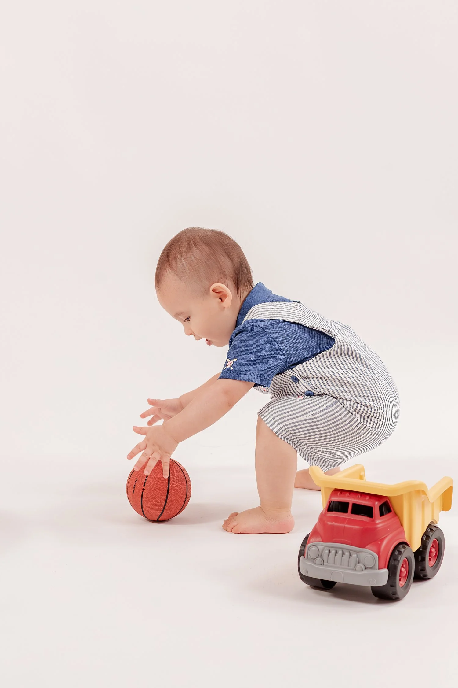 Winston reaching for a toy basketball beside the dump truck