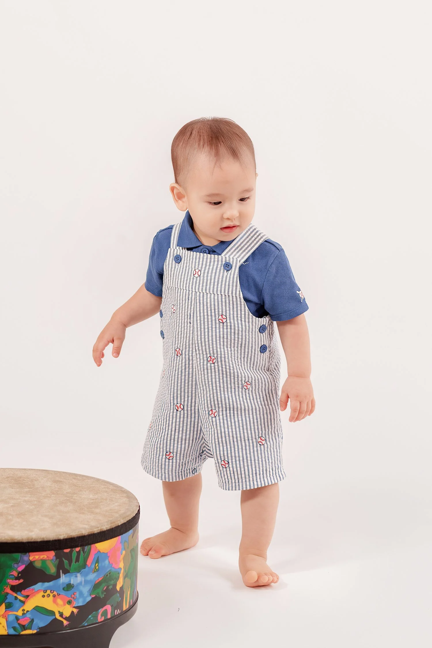 Winston standing next to his drum and looking down