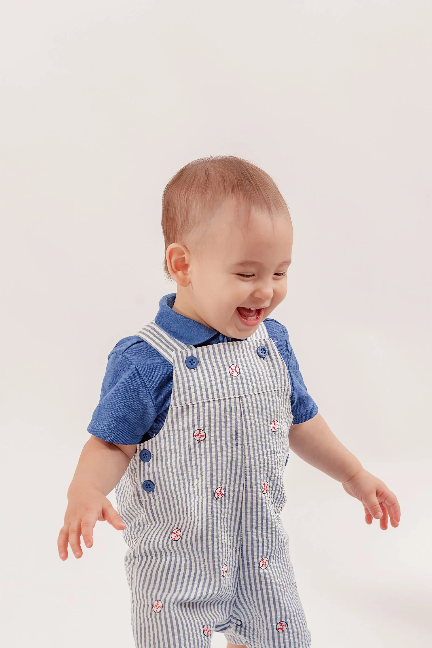 Close-up of Winston laughing in blue striped overalls