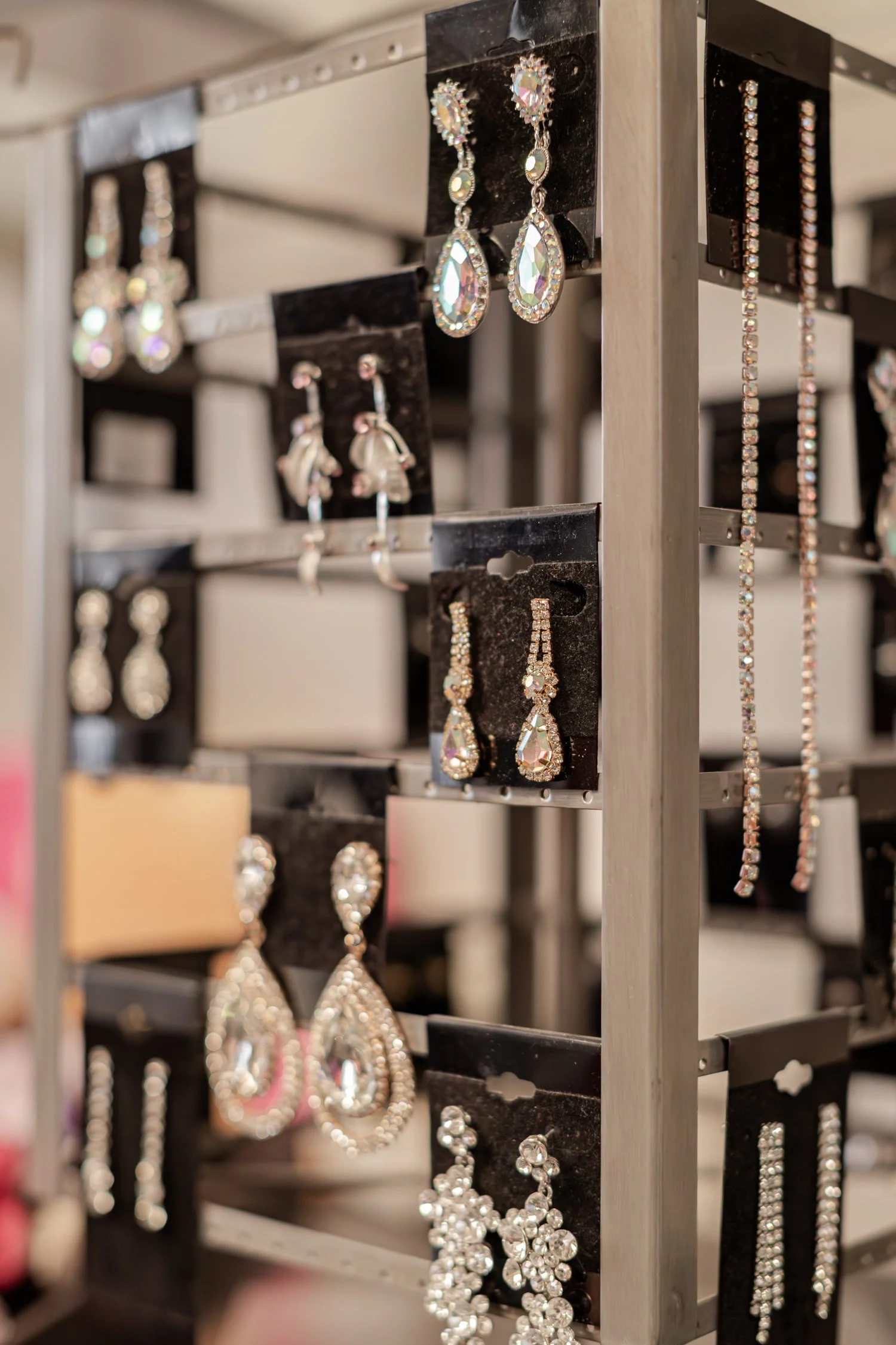 Rhinestone earrings on black cards on a metal rack, brand photos for H&H New Creations Boutique in Bolivar MO