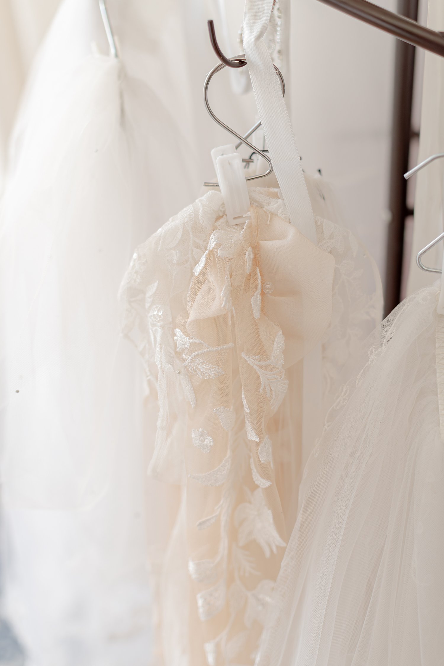 Blush lace gown with a satin bow beside white tulle, brand photos for H&H New Creations Boutique in Bolivar MO