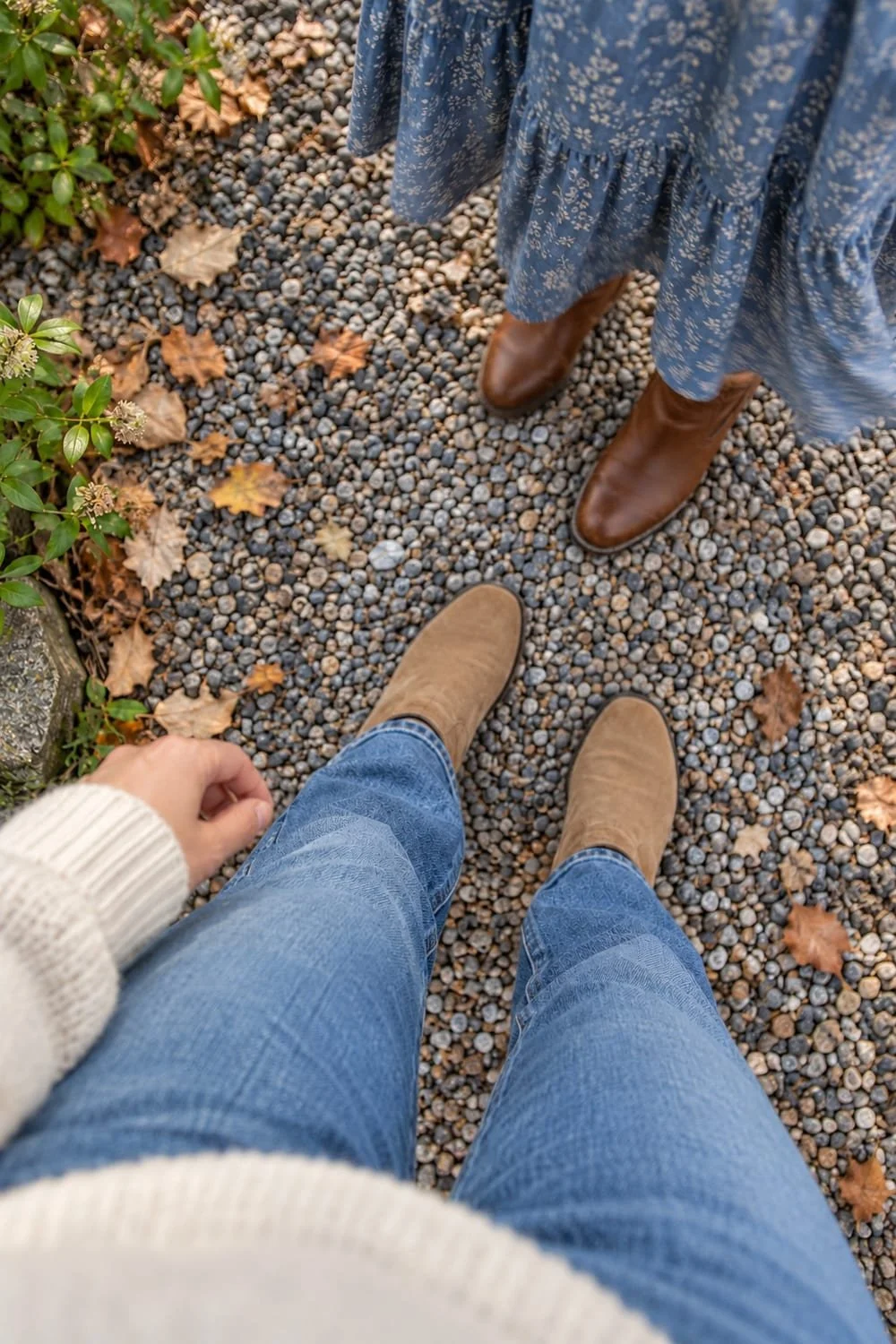 A teen’s view of tan ankle boots and jeans beside a parent’s blue dress and brown boots.