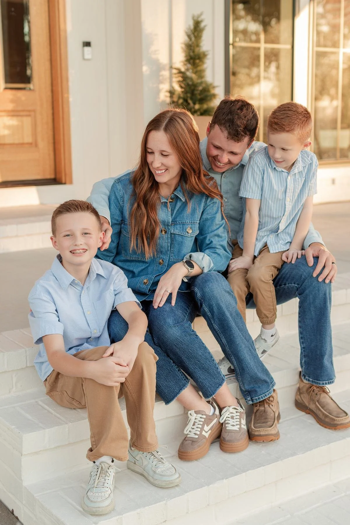 Two blue denim shirts beside light blue tops and tan pants in a family portrait.
