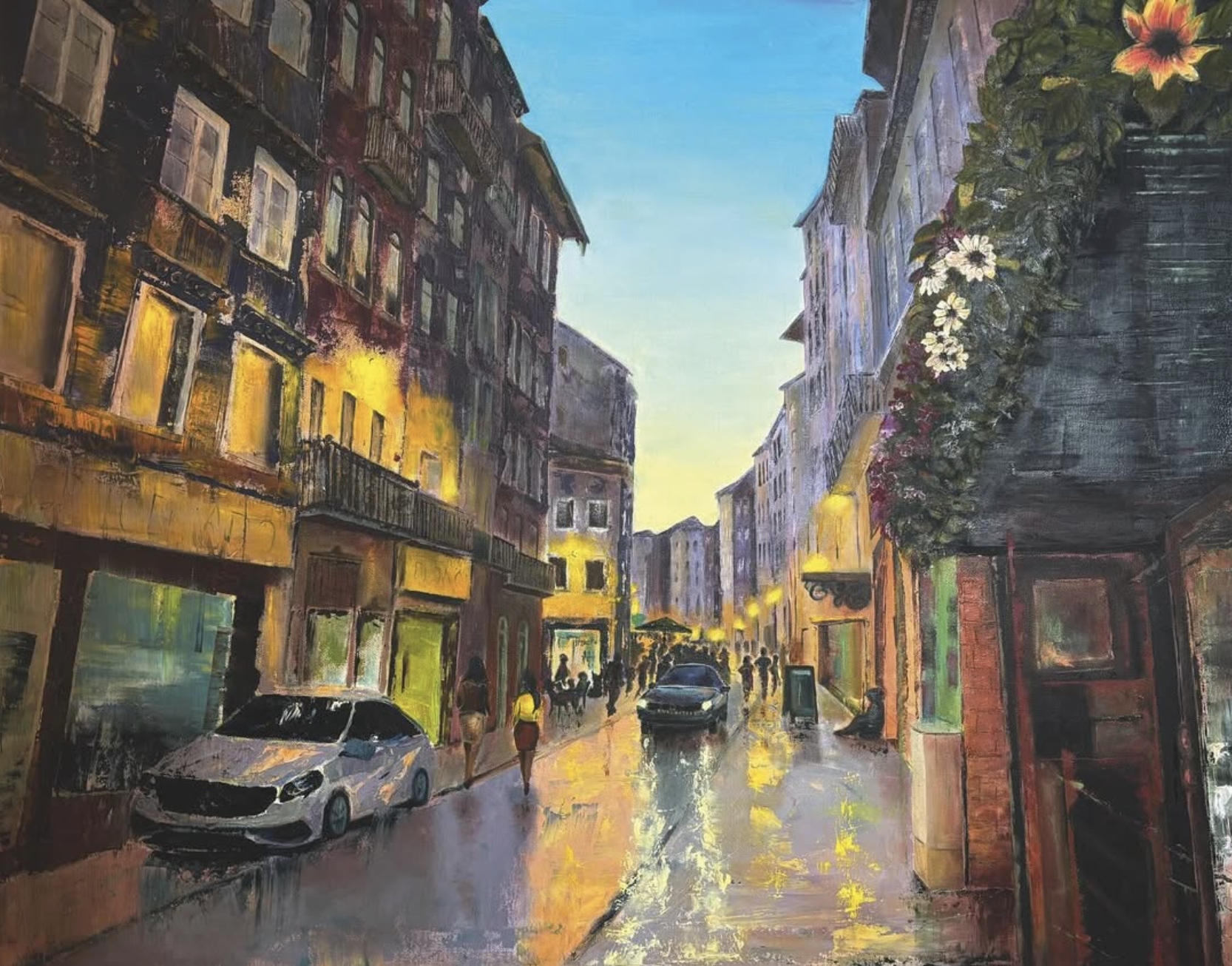 Ein Stadtbild bei Sonnenuntergang mit mehrstöckigen Gebäuden, die mit Fenstern und Balkonen versehen sind. Es gibt mehrere Fahrzeuge auf der nassen Straße, Menschen laufen und sitzen an der Straße, während die Laternen Licht spenden. Eine Wand auf de