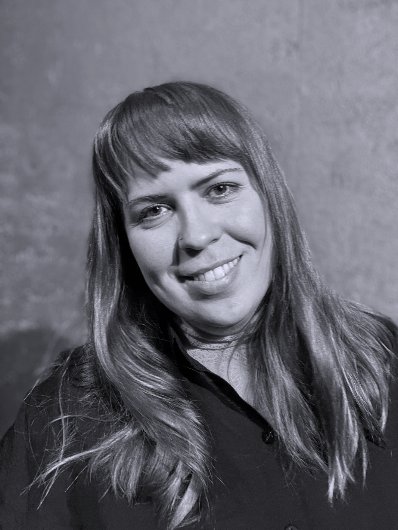 Mustavalkoinen lähikuva Liisasta, joka hymyilee valloittavasti kameralle.