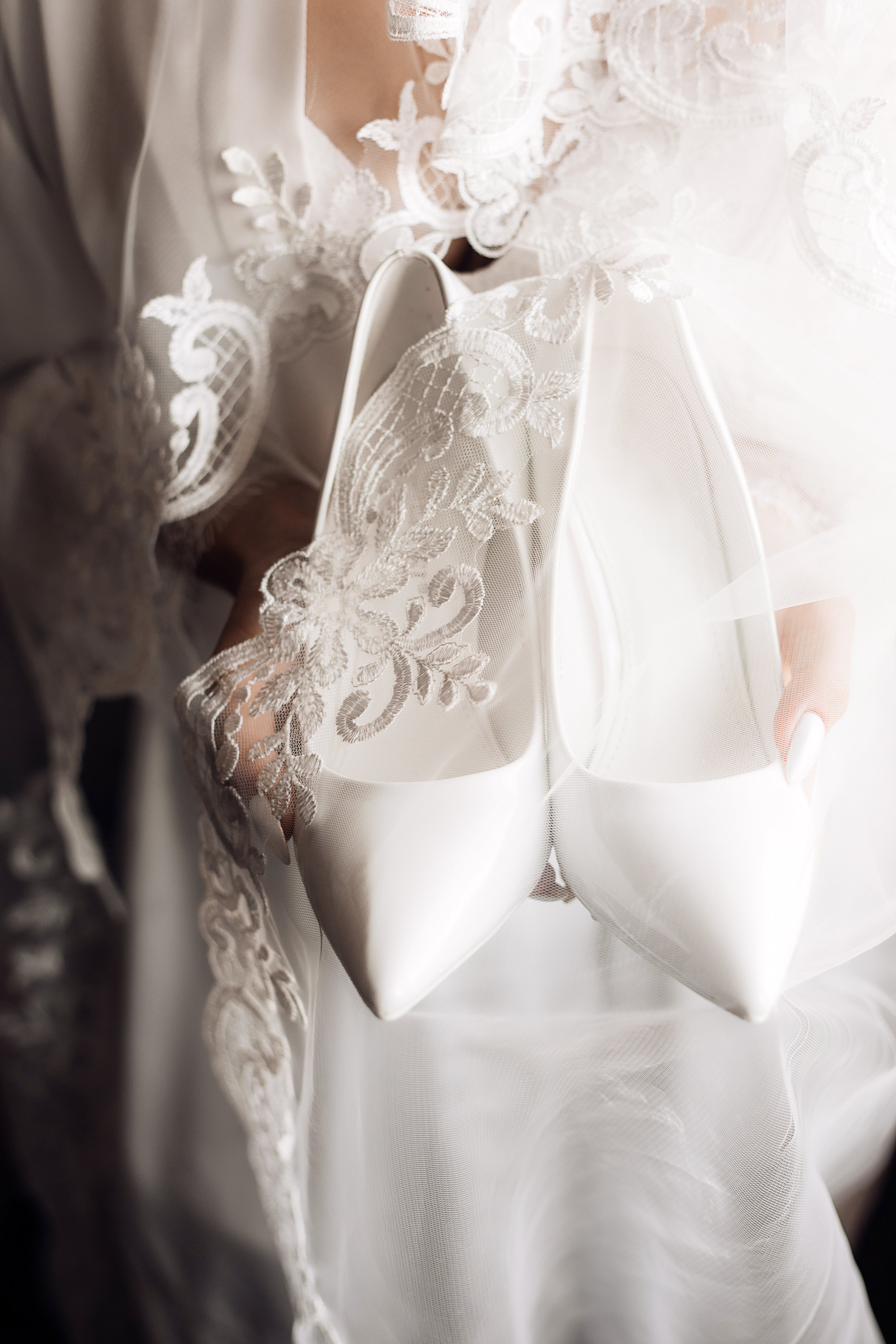 white-wedding-ceremonial-shoes-hands-bride-dressed-silk-nightwear-with-lace.jpg
