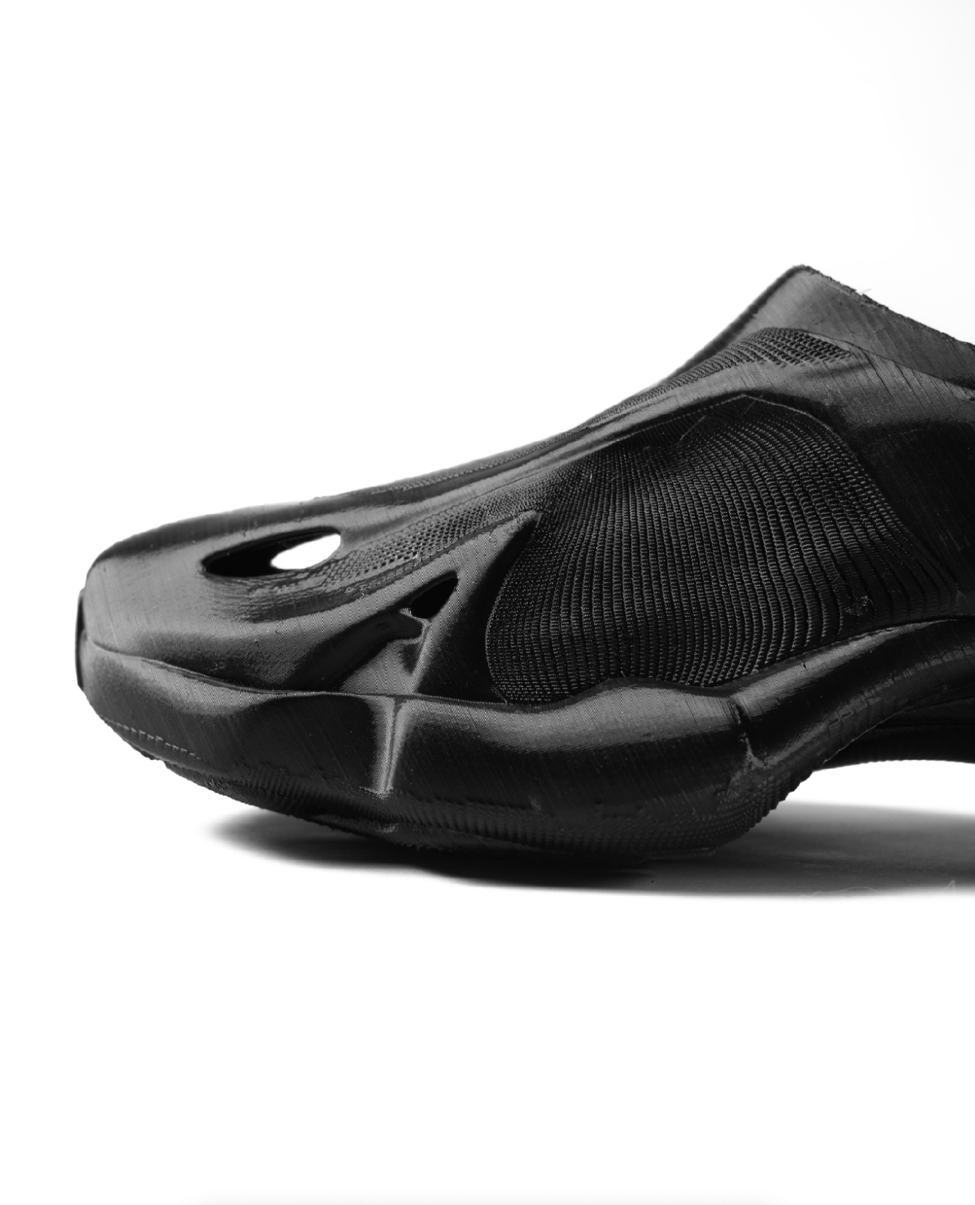 Close-up of a black athletic shoe with a sleek design, viewed from above on a white background.