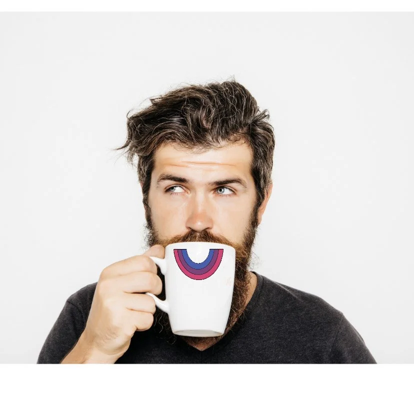 A man drinks from a mug with a bisexual rainbow symbol