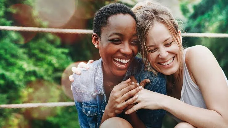 Two women embrace warmly and intimately