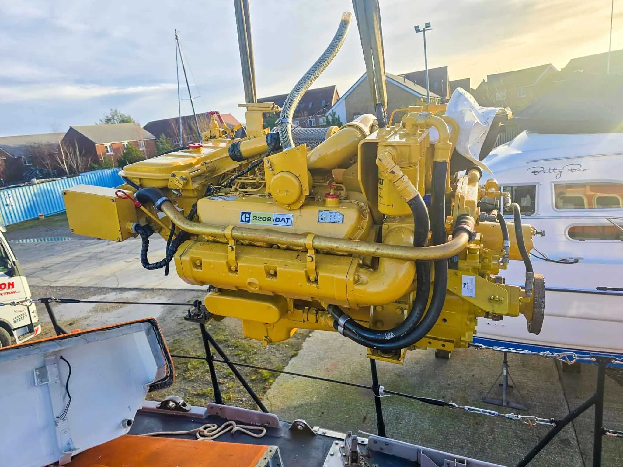 A smiling middle-aged woman with shoulder-length gray hair, wearing a white turtleneck sweater and glasses on her head, against a plain light-colored background.